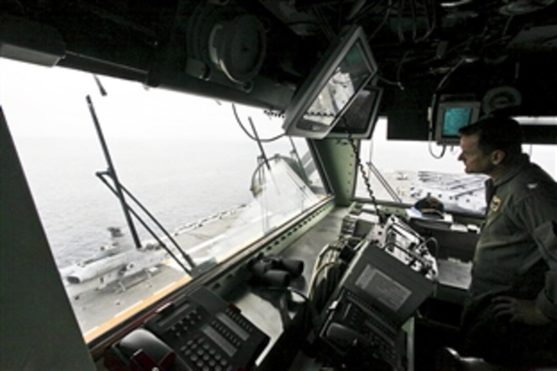 U.S. Navy Capt. Jim Landers watches an AH-1W Super Cobra aircraft prepare to take off from the USS Makin Island in the Pacific Ocean, Oct. 3, 2010. Landers is the ship's commanding officer. The 11th Marine Expeditionary Unit is the first amphibious landing force to embark the Makin Island, which set sail for San Francisco Oct. 1 to participate in the city's Fleet Week.