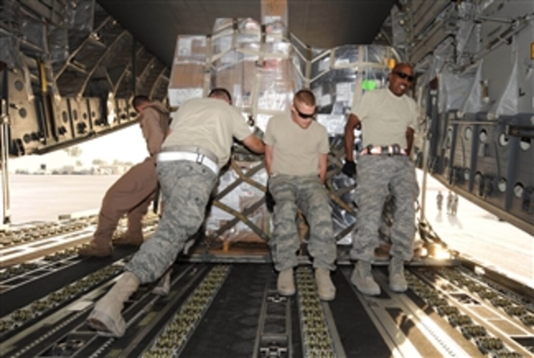U.S. Air Force airmen from the 451st Aerial Port Flight push a pallet of cargo as they unload a C-17 Globemaster III aircraft at Kandahar Airfield, Afghanistan, on Sept. 29, 2010.  Airmen with the flight handled more than 26 million pounds of cargo in the month of September.  