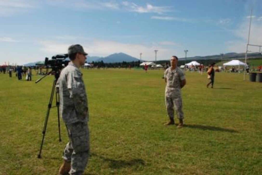 An Airforce reporter interviews Cpl Tadehara about his opinion of the ongoing Fuji Friendship Festival.