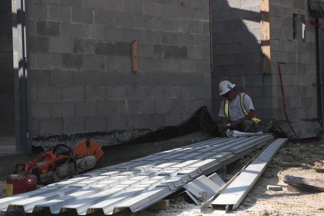 A contractor looks over some plans in preparation for working on the roof of one of the two Child Development Centers under construction on Brewster Boulevard aboard Marine Corps Base Camp Lejeune, Oct. 6. Three other CDCs are being built across the base, doubling the base's CDC capacity from five to 10.