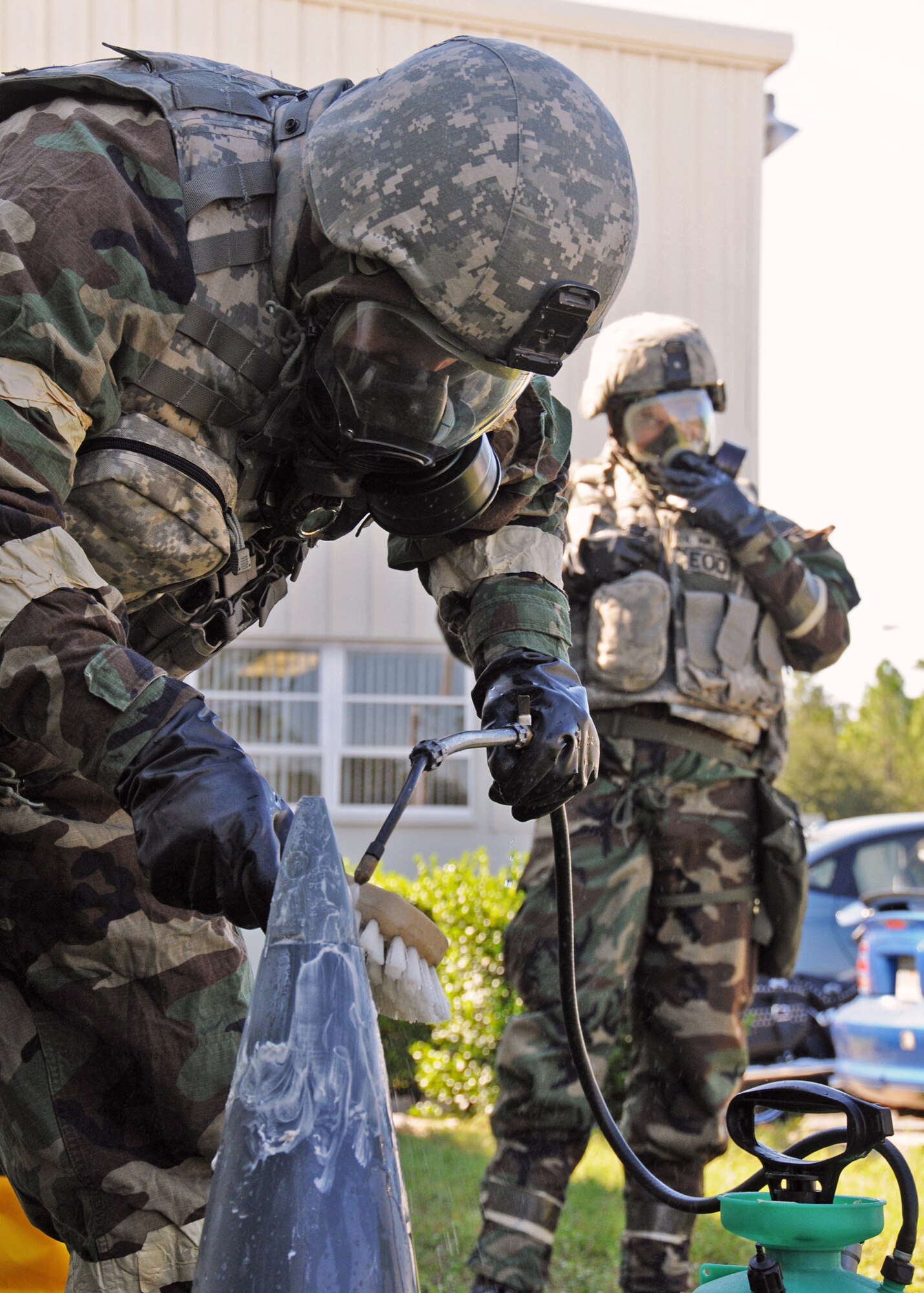 Tech. Sgt. Greg Locke, 919th Civil Engineer Squadron explosive ordnance disposal, rinses the contaminated ordnance after it was discovered at the 919th Maintenance Group building during Day two of the wing’s Ability to Survive and Operate exercise, Oct. 3 at Duke Field, Fla.  The Reserve unit exercised preparing deployers, Mission Oriented Protective Posture and command and control procedures during the Unit Training Assembly weekend.  (U.S. Air Force photo/Tech. Sgt. Samuel King Jr.)