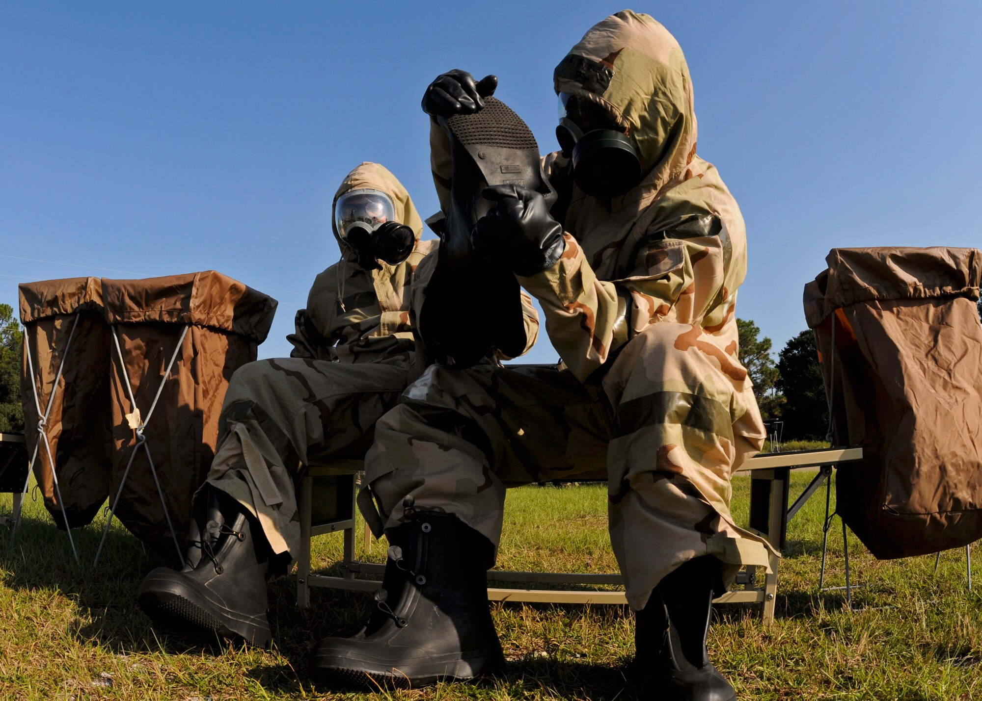Simulated contamination victims follow proper removal procedures to remove their boots in the decontamination area during Day two of the 919th Special Operations Wing’s Ability to Survive and Operate exercise, Oct. 3 at Duke Field, Fla.  The Reserve unit exercised preparing deployers, Mission Oriented Protective Posture and command and control procedures during the Unit Training Assembly weekend.  (U.S. Air Force photo/Tech. Sgt. Samuel King Jr.)