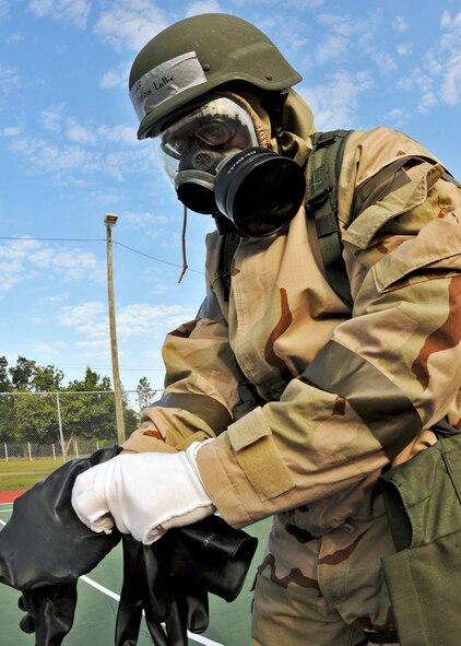Master Sgt. Marion Lollis, 919th Maintenance Group, pulls on his two sets of chemical warfare protection gloves during Day two of the wing’s Ability to Survive and Operate exercise, Oct. 3 at Duke Field, Fla.  The Reserve unit exercised preparing deployers, Mission Oriented Protective Posture and command and control procedures during the Unit Training Assembly weekend.  (U.S. Air Force photo/Tech. Sgt. Samuel King Jr.)
