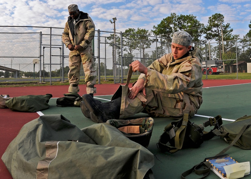 Staff Sgt. Undray Smith and Senior Airman Ian Drain gear up as simulated contamination victims during Day two of the wing’s Ability to Survive and Operate exercise, Oct. 3 at Duke Field, Fla.  The Reserve unit exercised preparing deployers, Mission Oriented Protective Posture and command and control procedures during the Unit Training Assembly weekend.  (U.S. Air Force photo/Tech. Sgt. Samuel King Jr.)