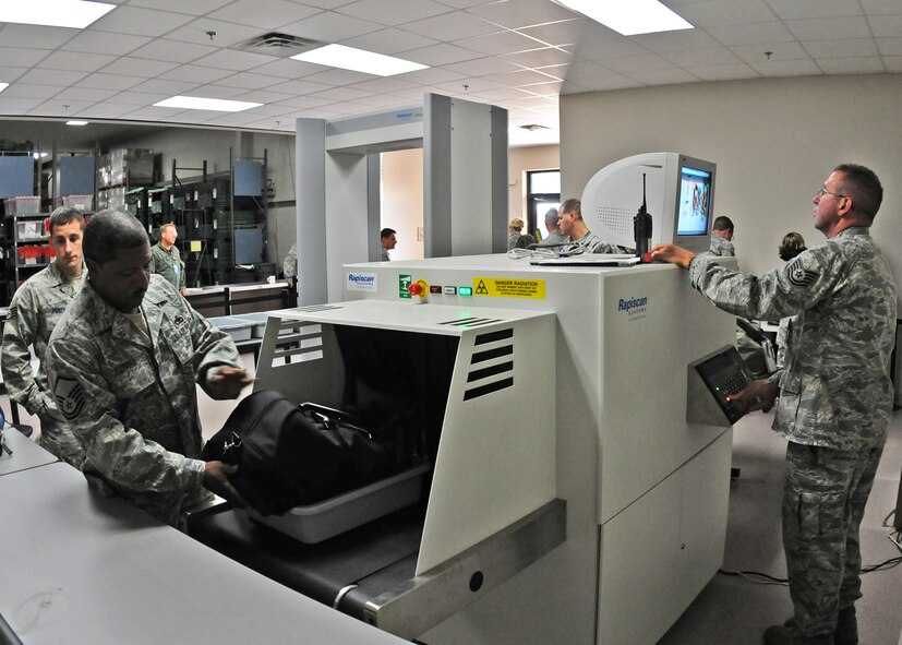 Master Sgt. Slyvester Futrell, 919th Maintenance Squadron, sends his bag through to be scanned by 919th Logistics Readiness Squadron personnel during Day one of the 919th Special Operations Wing’s Ability to Survive and Operate exercise, Oct. 2 at Duke Field, Fla.  The Reserve unit exercised preparing deployers, Mission Oriented Protective Posture and command and control procedures during the Unit Training Assembly weekend.  (U.S. Air Force photo/Tech. Sgt. Samuel King Jr.)