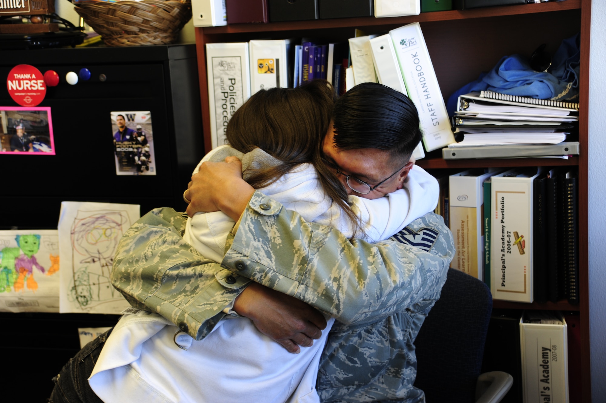 Tech. Sgt. Raymond Ibay, 627th Air Base Group vehicle maintenance craftsman embraces his daughter, Paxton Baker, after surprising her with his presence Oct. 5 at Iva Alice Mann Middle School, Lakewood, Wash. (U.S. Air Force Photo/Airman Leah Young)