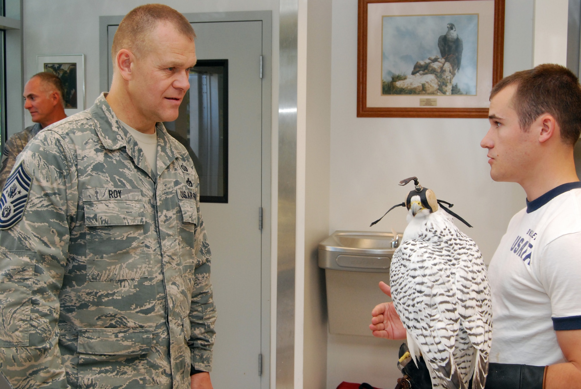 Cadet 2nd Class Michael O'Kelley, right, talks to Chief Master Sgt. of the Air Force James Roy about the Air Force Academy's falconry program during a visit to the Academy's mews Oct. 1, 2010. The mews is a special facility designed to house the Academy's 12 falcons, including Aurora, a gyrfalcon and the Academy's current mascot. (U.S. Air Force photo/Staff Sgt. Don Branum)
