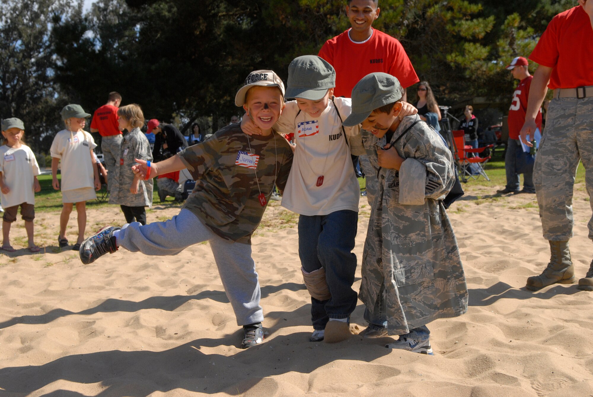 VANDENBERG AIR FORCE BASE, Calif. -- Jeffrey Dodge and Chance Azevedo, military dependents, help Adam Balts, a military dependent, hop across the sand during a simulated self aid and buddy care exercise at Cocheo Park here Saturday, Oct. 2, 2010.  The exercise was a part of the Operations Kids Understanding Deployment Operations event to show dependents how military members prepare for deployments.  (U.S. Air Force photo/Senior Airman Andrew Satran) 

 