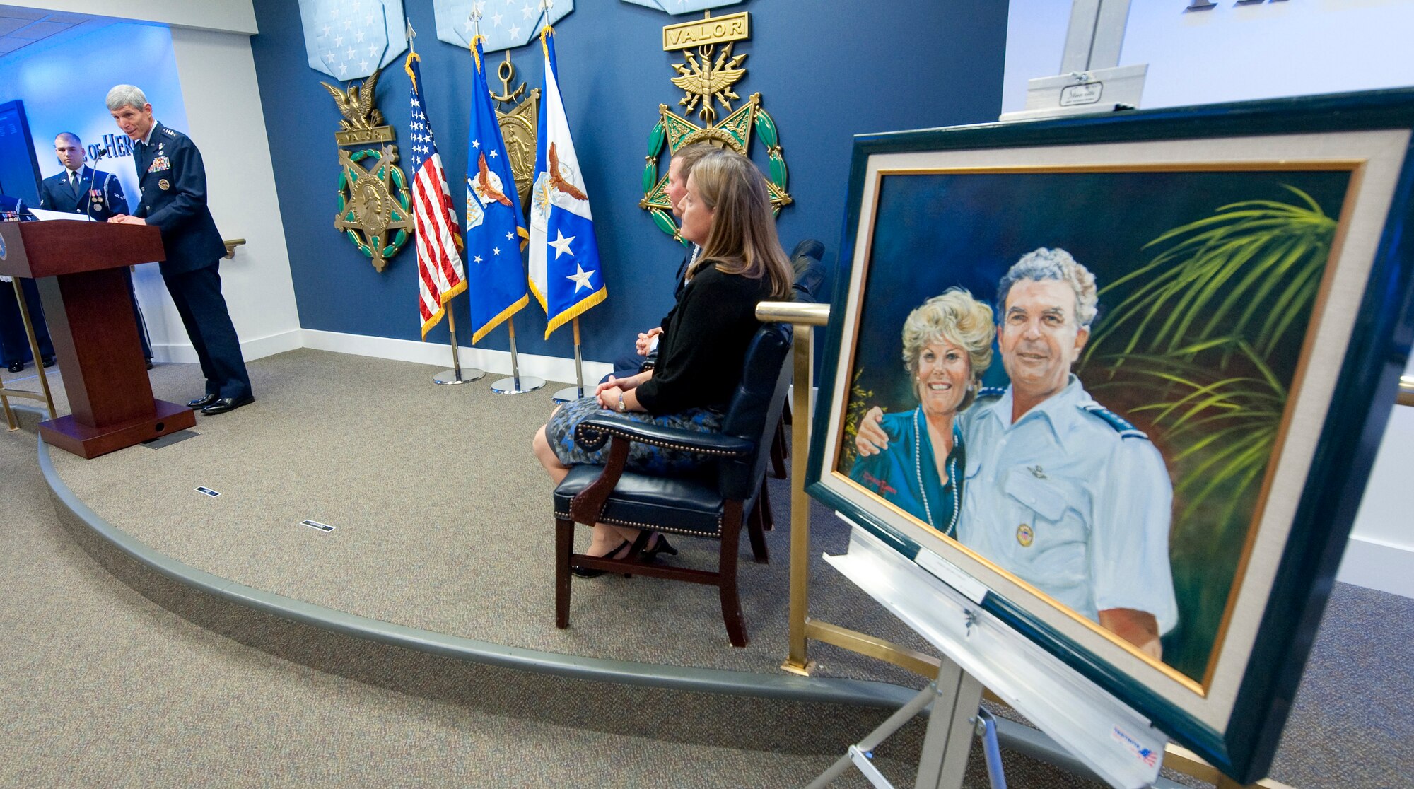 Air Force Chief of Staff Gen. Norton Schwartz (left) introduces Brig. Gen. Thomas W. Bergeson and his wife Pamela during a ceremony in the Pentagon Oct. 4, 2010, prior to presenting them with the General and Mrs. Jerome F. O'Malley award. The award is presented annually to the wing commander and spouse team who have best exhibited their own courage, power, grace and beauty in caring for Air Force families. The award was established after the O'Malleys, shown in the oil painting, who were known for their leadership and contributions to Air Force families and communities, were tragically killed in a plane crash in 1985. (U.S. Air Force photo/Jim Varhegyi)