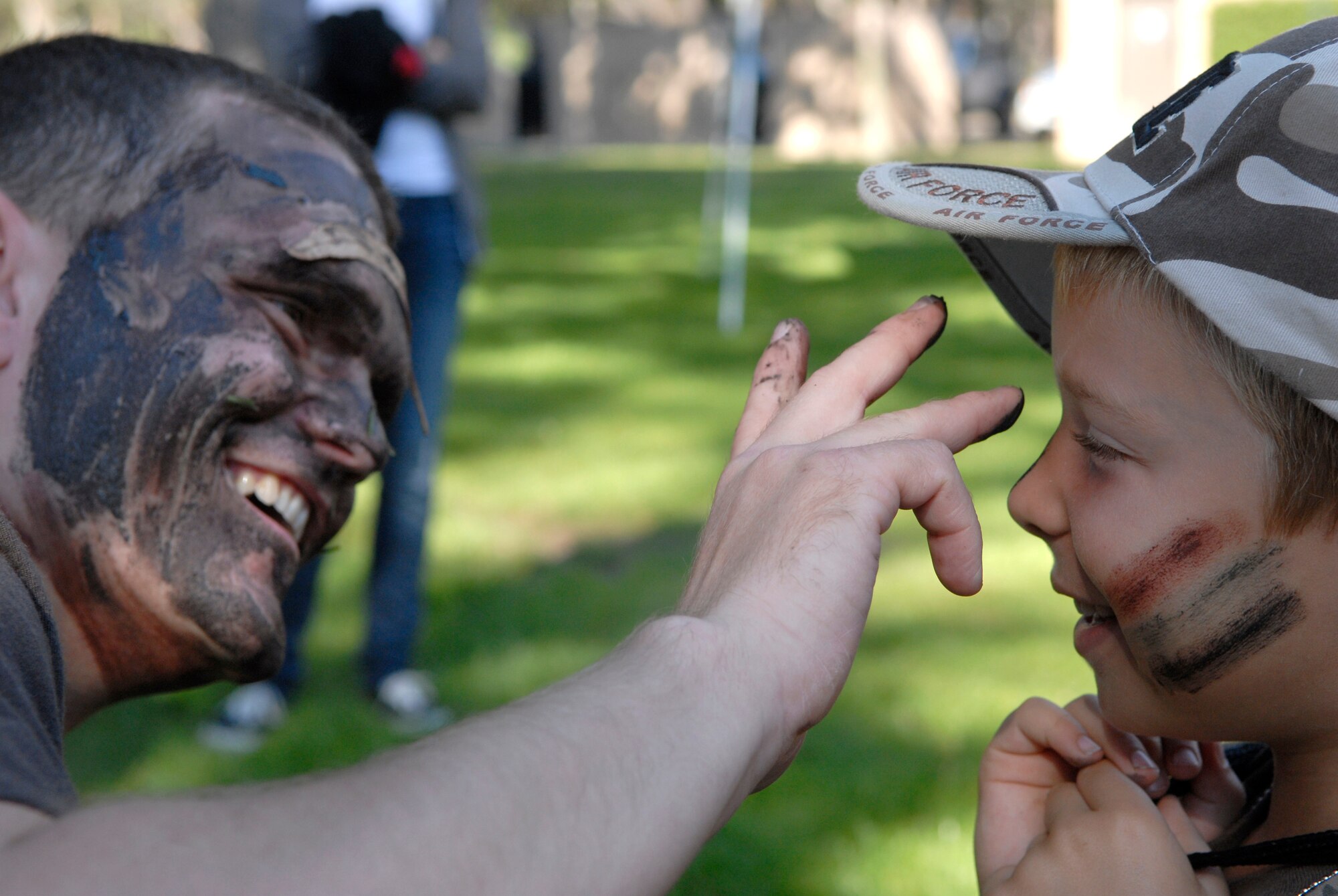 VANDENBERG AIR FORCE BASE, Calif. -- David Jung, a 532nd Training Squadron member, puts the warrior paint on Jeffrey Dodge, a military dependent during the Operation Kids Understanding Deployment Operations event at Cocheo Park here Saturday, Oct. 2, 2010.  KUDOS simulated a deployment processing line for dependents to help them understand the deployment process their parents or guardians go through. (U.S. Air Force photo/Senior Airman Andrew Satran) 
 