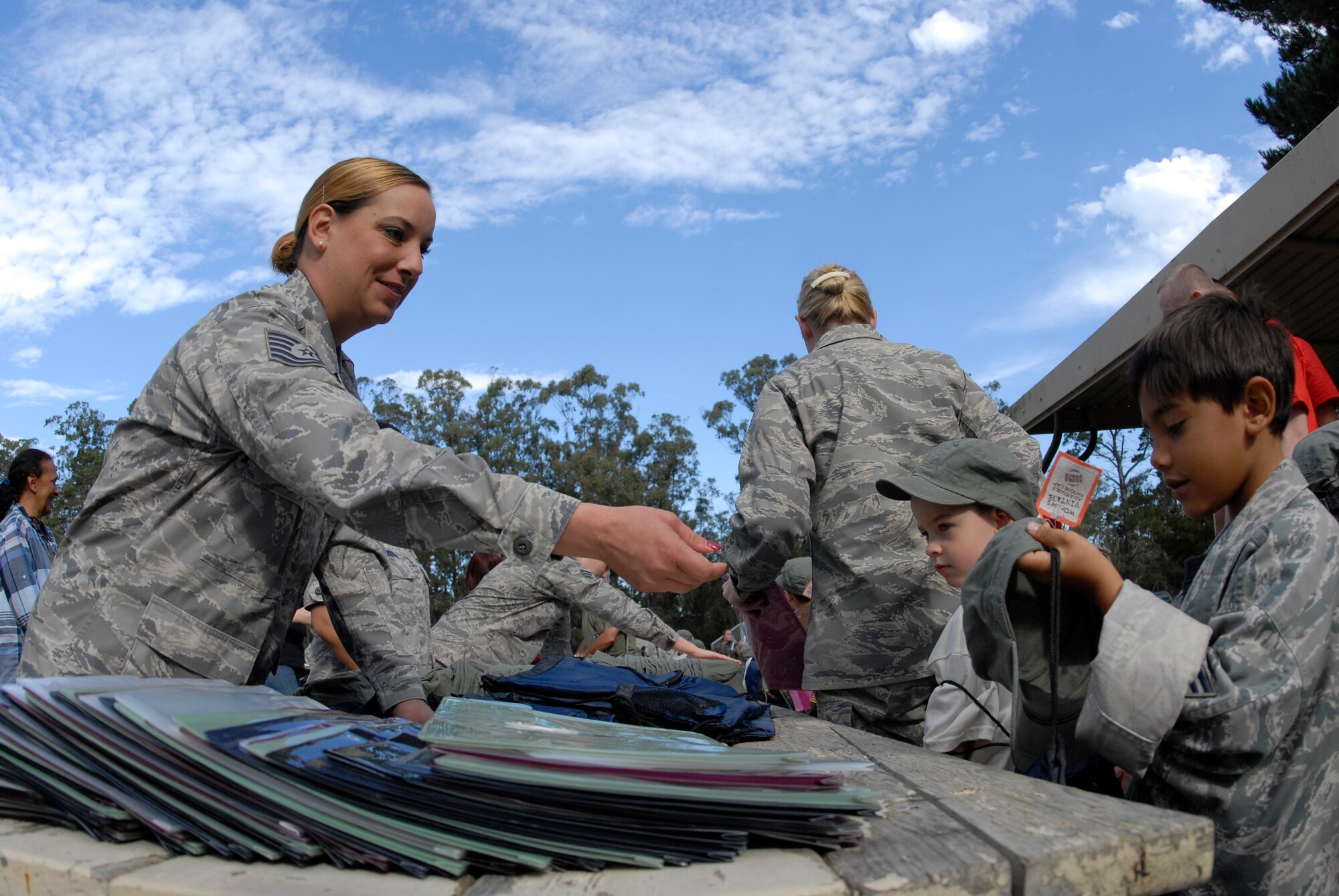 VANDENBERG AIR FORCE BASE, Calif. -- Handing out deployment gear, Tech Sgt. Therese Davis, from the 30th Force Support Squadron, gives a bag to a military dependent during the Operation Kids Understanding Deployment Operations event at Cocheo Park here Saturday, Oct. 2, 2010.  KUDOS put dependents on a simulated deployment to show them the deployment process through games and activities.  (U.S. Air Force photo/Senior Airman Andrew Satran) 

 