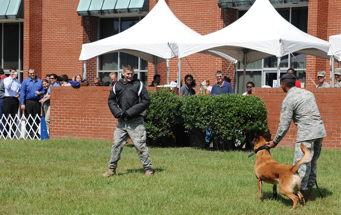 U.S. Air Force Staff Sgt. Fazel Munshi, far right, and his military working dog, Arton, stand by as U.S. Air Force Staff Sgt. Craig Martin plays the role of an uncooperative suspect during a demonstration at the Joint Base Charleston  inaugural open house at the Red Bank Club on JB CHS-Weapons Station, S.C., Oct. 1, 2010. The event was open to all members of JB CHS and the local community. (U.S. Air Force photo/Senior Airman Timothy Taylor)