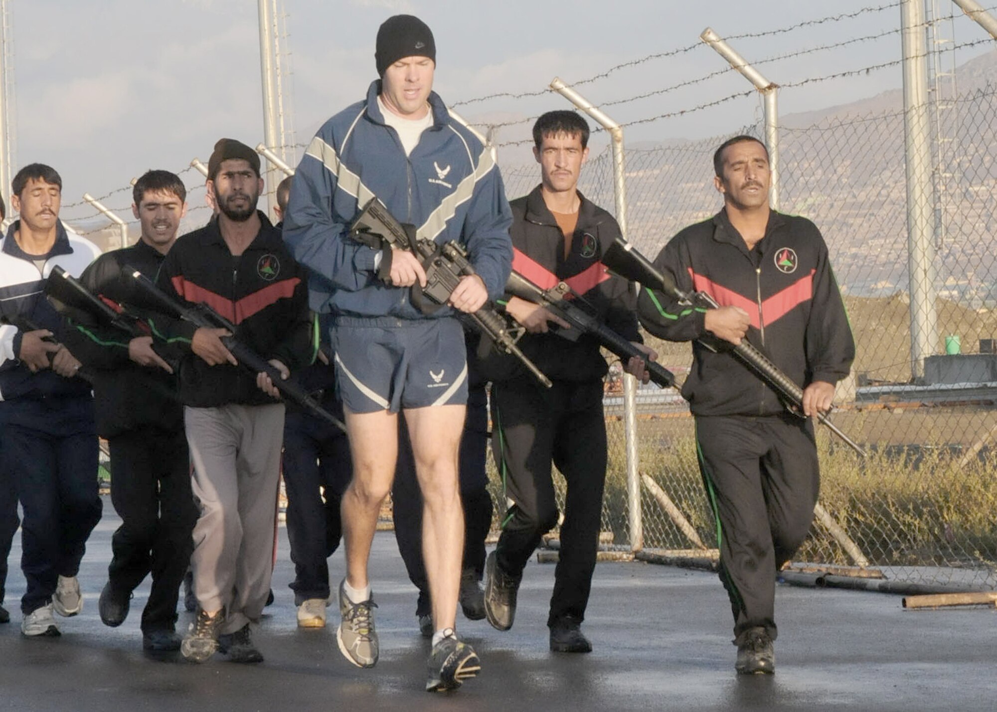 Afghan air force security forces members engage in physical fitness with Capt. Robert Shaw Sept 30, 2010, in Kabul, Afghanistan. Captain Shaw is the NATO Air Training Command - Afghanistan adviser. (U.S. Navy photo/Petty Officer 3rd Class Jared Walker)