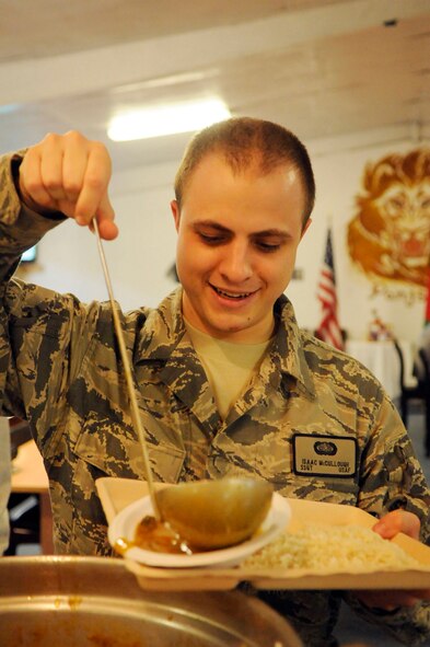 PANJSHIR PROVINCE, Afghanistan -- Staff Sgt. Isaac McCullough, a native of Carrollton, Ohio, Provincial Reconstruction Team Panjshir tactical operations center radio telephone operator and S6 technician, serves himself a bowl of Louk's gumbo for dinner. Tech. Sgt. Jeremy Louk, a native of Petal, Miss., deployed from Barksdale Air Force Base, La., Provincial Reconstruction Team Panjshir engineering superintendent of construction and development, prepared a 23-ingredient gumbo for more than 100 personnel deployed to Forward Operating Base Lion. Members of FOB Lion ate the entire 40 quarts of gumbo. (U.S. Air force photo by Tech. Sgt. Sean Mateo White, PRT Panjshir photographer)(released)    