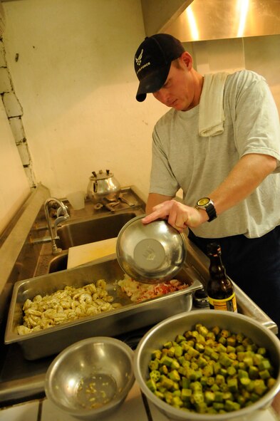 PANJSHIR PROVINCE, Afghanistan -- Tech. Sgt. Jeremy Louk, a native of Petal Miss., deployed from Barksdale Air Force Base, La., Provincial Reconstruction Team  Panjshir engineering superintendent of construction and development, tosses the main gumbo ingredients in a mixture of 15 different spices and seasonings prior to adding them to the pot. A few on the gumbo ingredients were shrimp, lobster, crab meat, chicken and okra. The okra was purchased in a local market in Panjshir, Afghanistan. (U.S. Air force photo by Tech. Sgt. Sean Mateo White, PRT Panjshir photographer)(released)   