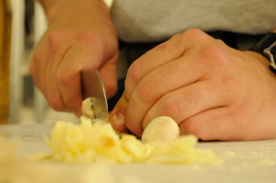PANJSHIR PROVINCE, Afghanistan -- Tech. Sgt. Jeremy Louk, a native of Petal, Miss., deployed from Barksdale Air Force Base, La., and Provincial Reconstruction Team Panjshir engineering superintendent of construction and development, dices up several garlic cloves to add to his gumbo. Including preparation time, it took Louk nearly 10 hours to make the gumbo. (U.S. Air Force photo by Tech. Sgt. Sean Mateo White, PRT Panjshir photographer)(released)  