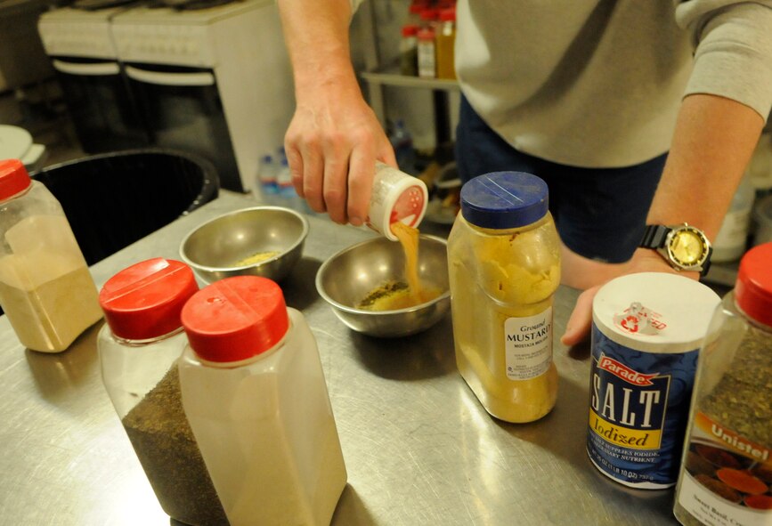 PANJSHIR PROVINCE, Afghanistan -- Tech. Sgt. Jeremy Louk, a native of Petal, Miss., deployed here from Barksdale Air Force Base, La., and Provincial Reconstruction Team Panjshir engineering superintendent of construction and development, mixes a bowl of 15 different spices and seasonings. The chicken, shrimp, lobster and crab meat all were lightly covered with the mix prior to entering the pot of gumbo. Fourteen of the spices were either on hand in the dining facility at Forward Operating Base Lion, or purchased on the local economy. The fifteenth spice, Filet, Louk brought with him all the way from his home station of Barksdale Air Force Base, La. (U.S. Air Force photo by Tech. Sgt. Sean Mateo White)(released)  
