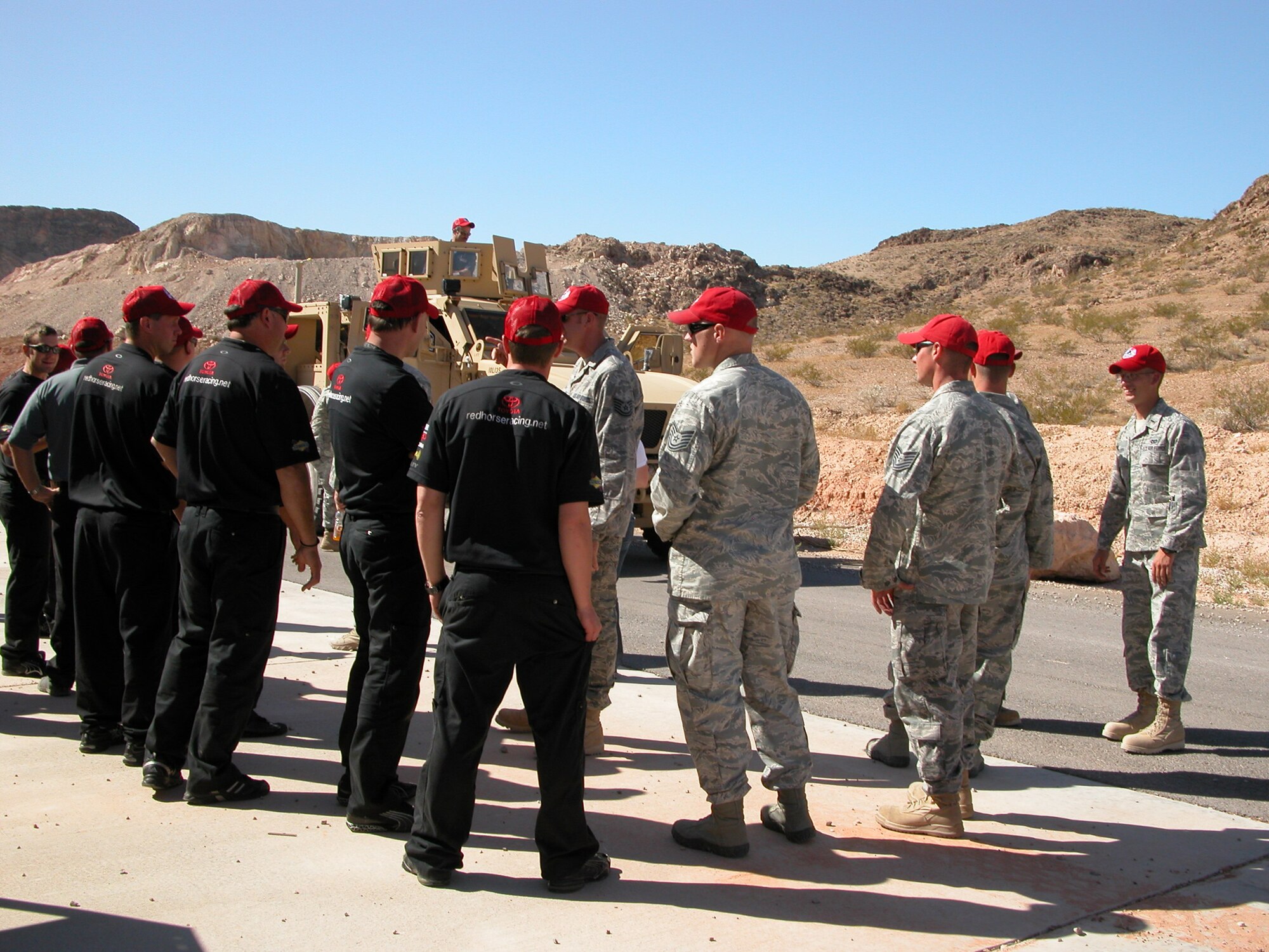 NELLIS AIR FORCE BASE, Nev.-- Members of the 820th RED HORSE Squadron explain to members of NASCAR's Red Horse Racing team the capabilities of a mine-resistant, ambush-protected all-terrain vehicle, or M-ATV, during a base visit here Sept. 24. The two "red horse" teams met for the first time after several years of anticipation. (U.S. Air Force photo / Tech. Sgt. Minette Mason)