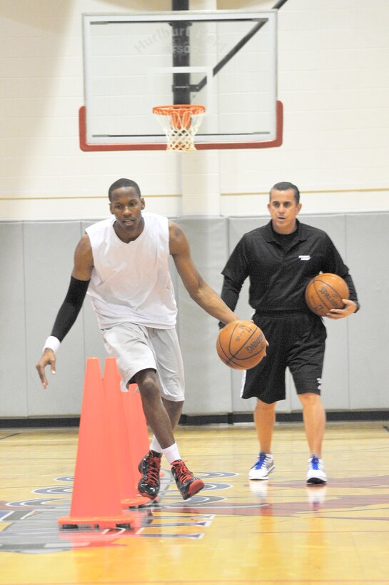 Capt. Antoine Hood works on his crossover dribble as Octavio DeLagrana looks on during a workout session at Sept. 29, 2010, Hurlburt Field, Fla. Captain Hood played college basketball at the Air Force Academy from 2002 through 2006 and after graduation played briefly with the NBA's Denver Nuggets. Captain Hood is assigned to the 919th Special Operations Wing and Mr. DeLagrana is a Miami Heat player development coach. (U.S. Air Force photo/Senior Airman Sheila deVera)