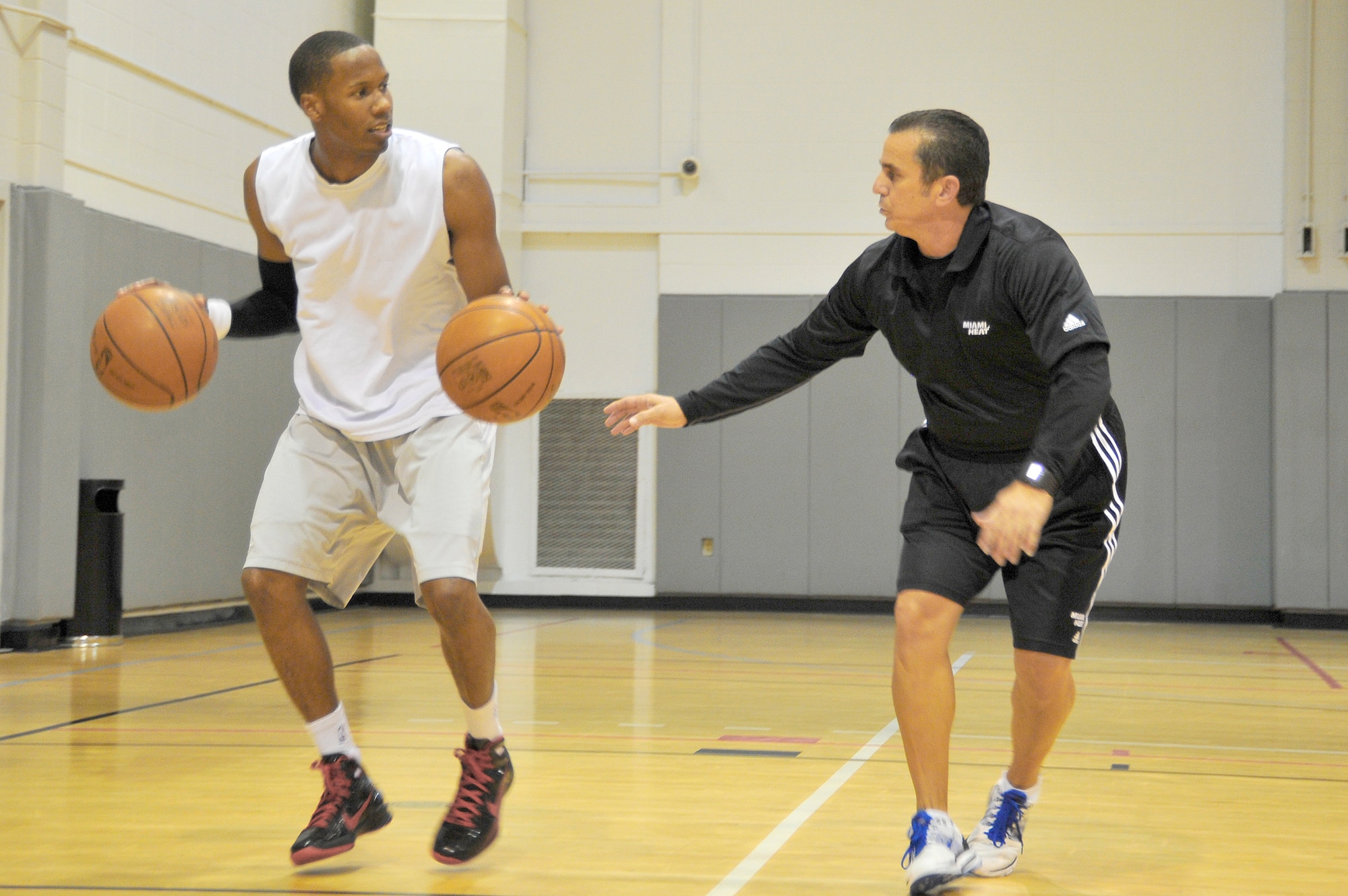 Octavio DeLagrana watches Capt. Antoine Hood work on his dribbling technique during a workout session Sept. 29, 2010, at Hurlburt Field, Fla. Captain Hood played college basketball at the Air Force Academy from 2002 through 2006 and after graduation played briefly with the NBA's Denver Nuggets. Captain Hood is assigned to the 919th Special Operations Wing and Mr. DeLagrana is a Miami Heat player development coach. (U.S. Air Force photo/Senior Airman Sheila deVera)