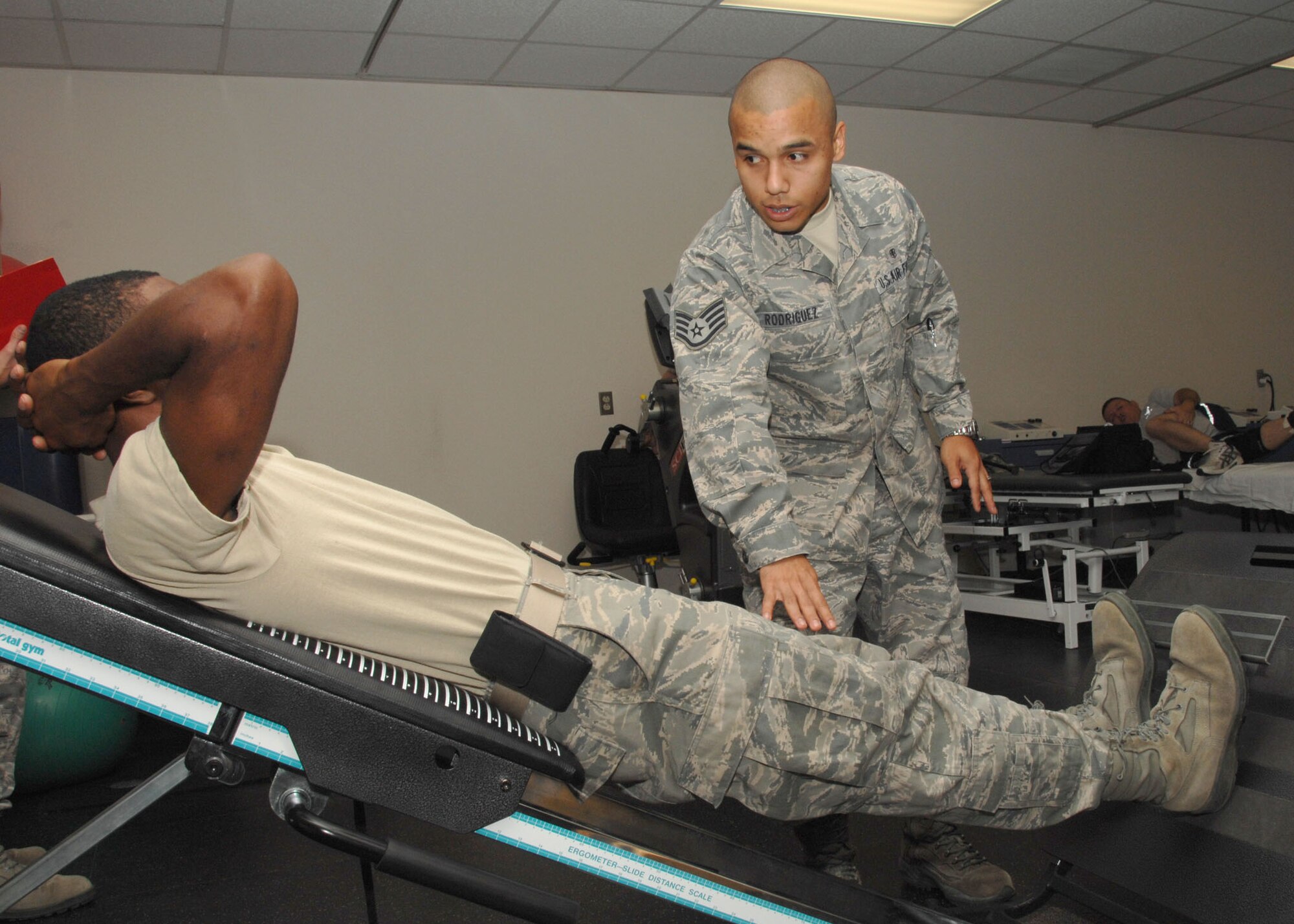Staff Sgt. Vicente Rodriguez, a physical therapist with the 59th Medical Wing, works with a patient on an exercise machine Oct. 5, 2010 at Wilford Hall Medical Center, Lackland Air Force Base, Texas.  As a safe and effective alternate to prescription drugs, physical therapists design a regimen of evidence-based physical treatment programs to meet the needs of patients according to injury. (U.S. Air Force photo/Harold China)