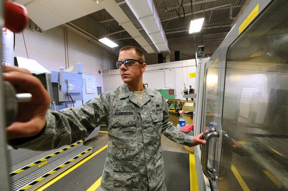 ELLSWORTH AIR FORCE BASE, S.D. – Senior Airman Nathan Schroeder, 28th Maintenance Squadron aircraft metals technology journeyman, adjusts the cutter rate during the milling of a spoiler bellcrank, Sept. 30. Airman Schroeder uses a computer numerical control machine to craft the bellcrank. (U.S. Air Force photo/Senior Airman Kasey Close)
