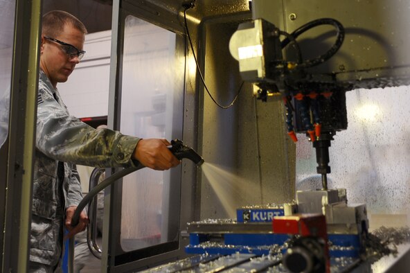 ELLSWORTH AIR FORCE BASE, S.D. – Senior Airman Nathan Schroeder, 28th Maintenance Squadron aircraft metals technology journeyman, cleans metal shavings off a computer numerical control machine before it continues milling a spoiler bellcrank, Sept. 30. Airman Schroeder spent more than 90 hours of programming to create the bellcrank, which is no longer manufactured. (U.S. Air Force photo/Senior Airman Kasey Close)