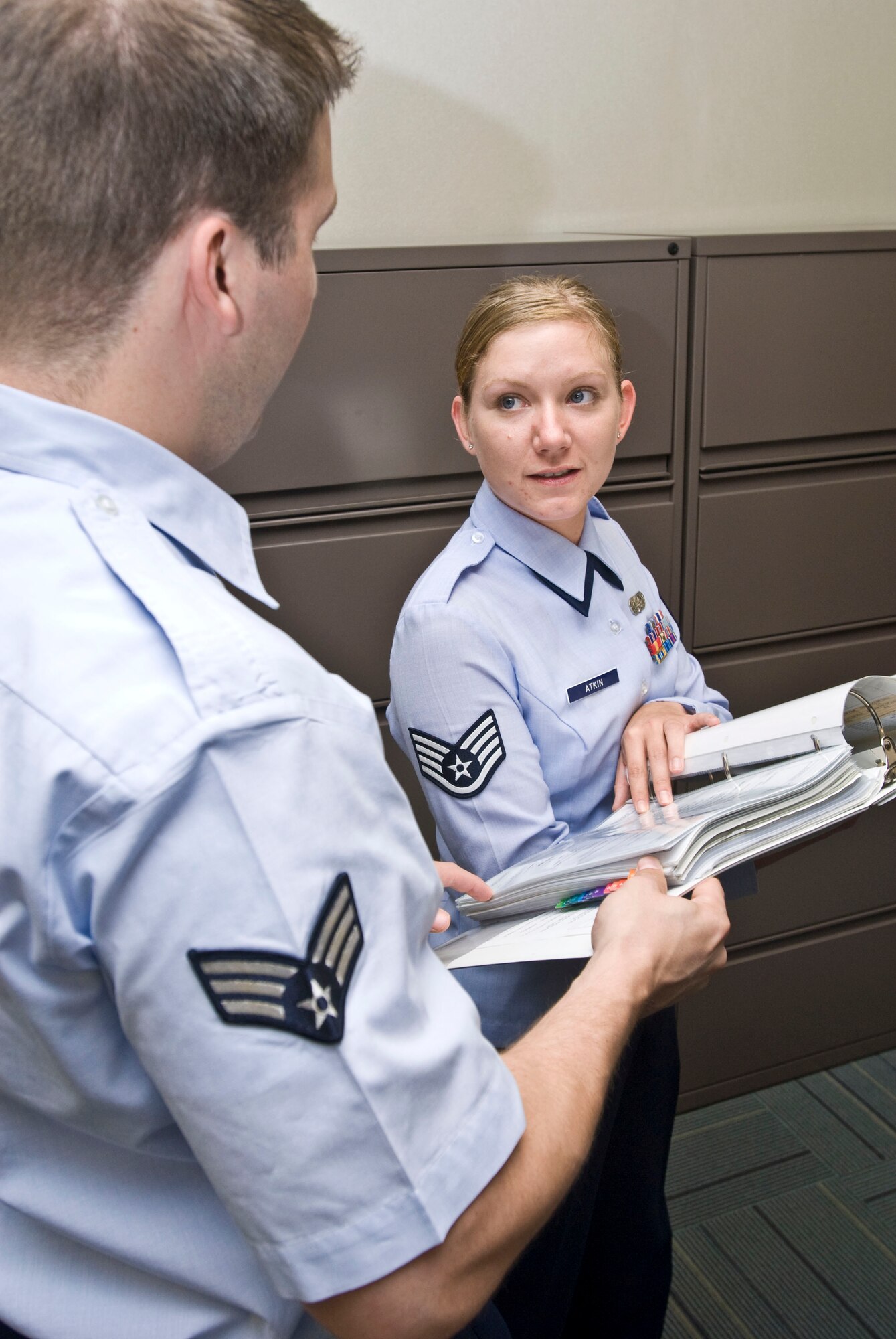 Staff Sgt. Misty Atkin, 19th Maintenance Group knowledge operator, goes over a file plan with a fellow Airman. The Rose Bud, Ark., native coordinated the group’s change of command ceremony including arranging for communications support and parking for distinguished visitors. (U.S. Air Force photo by Staff Sgt. Nestor Cruz)