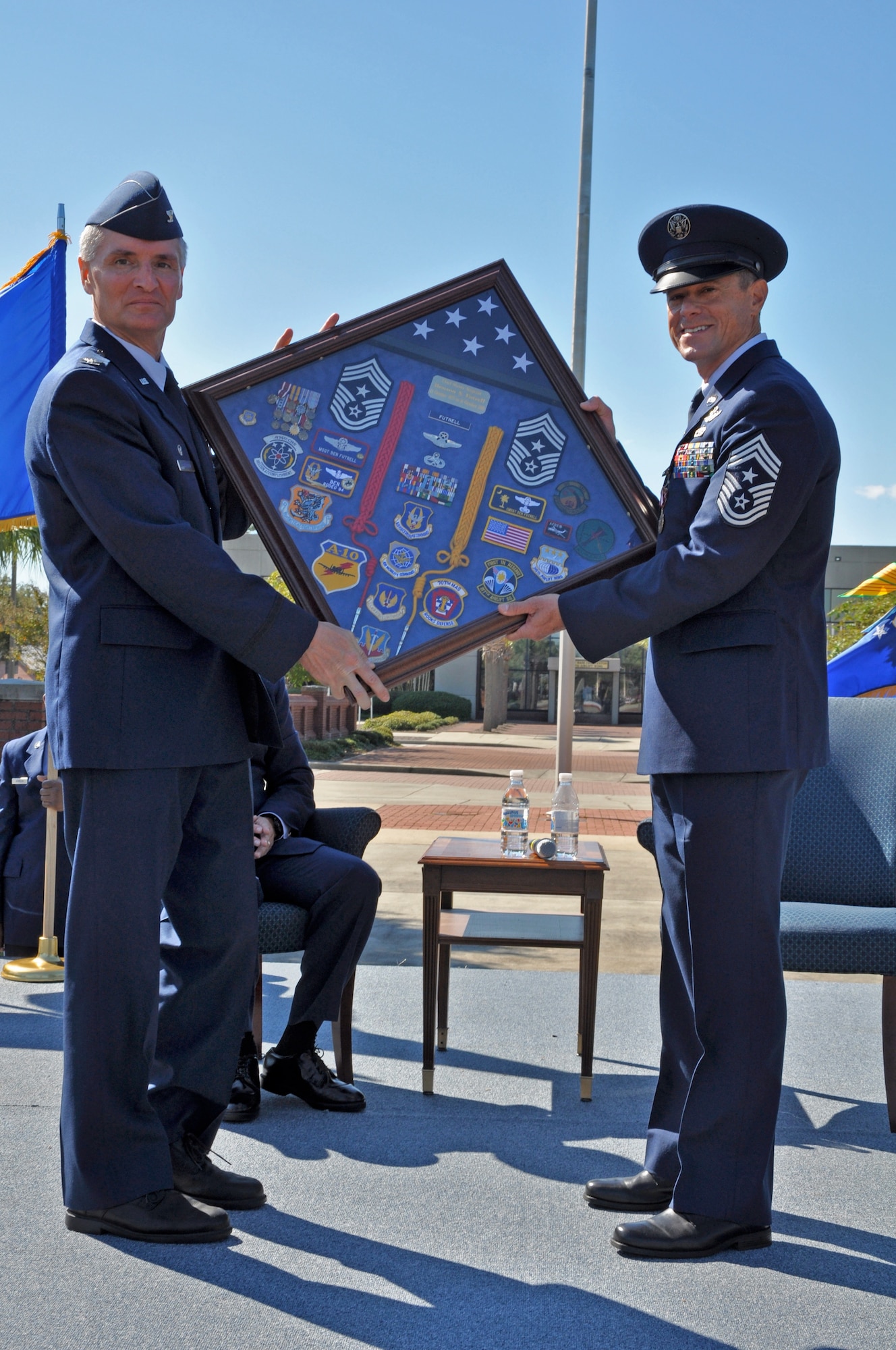 Col. Steven J. Chapman presents a shadow box to Chief Master Sgt. Benson S. (Ben) Futrell during his retirement ceremony Oct. 3, 2010 at the Joint Base Charleston flagpole. Colonel Chapman is the 315th Airlift Wing commander and Chief Futrell is retiring as the 315 AW command chief master sergeant. (U.S. Air Force photo/Staff Sgt. Shane Ellis)