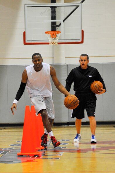 U.S. Air Force Capt. Antoine Hood, 919th Special Operations Wing, works on his crossover dribble as Octavio DeLagrana, Miami HEAT player development coach, looks on during a workout session at Hurlburt Field, Fla., Sept. 29, 2010. Captain Hood had a college basketball career at the Air Force Academy from 2002-2006.  (DoD photo by U.S. Air Force Senior Airman Sheila deVera/RELEASED)
