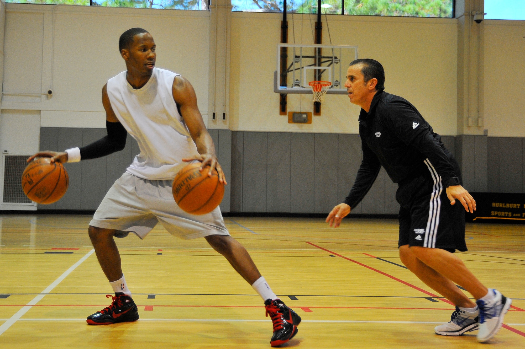 Octavio DeLagrana, Miami HEAT player development coach, works with U.S. Air Force Capt. Antoine Hood, 919th Special Operations Wing, on his dribbling technique during a workout session at Hurlburt Field, Fla., Sept. 29, 2010. Captain Hood had a college basketball career at the Air Force Academy from 2002-2006.  (DoD photo by U.S. Air Force Senior Airman Sheila deVera/RELEASED)


