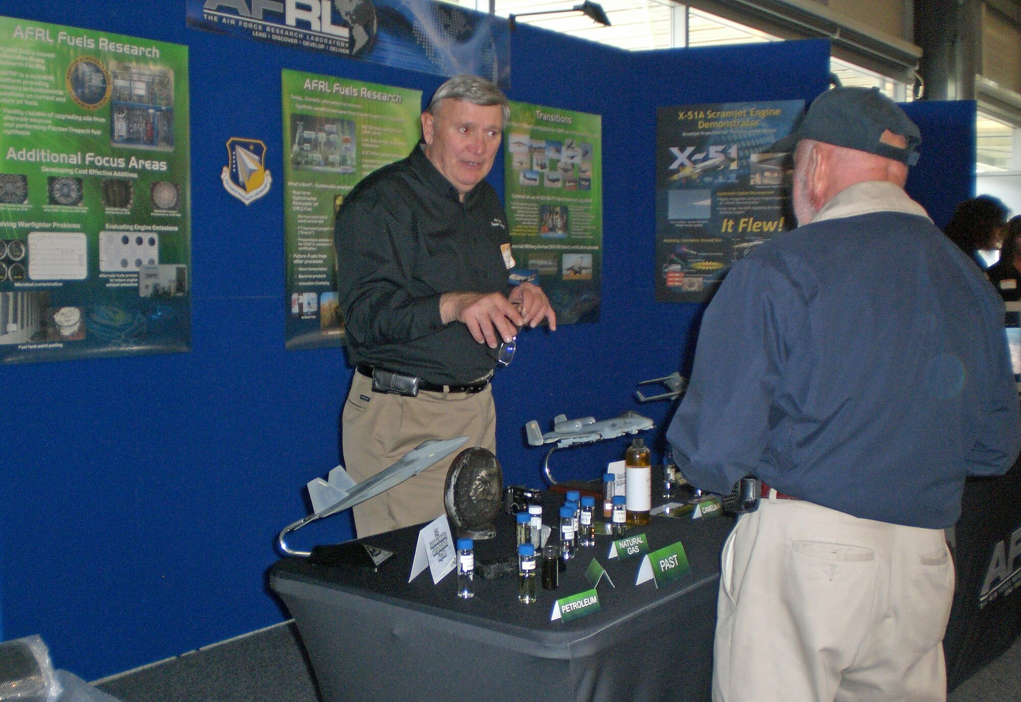 Adrian DeNardo explains how the Air Force investing in research, development and certification of advanced renewable biofuel blends to reduce demand for traditional petroleum-based JP-8 jet fuel. Mr. DeNardo was among Air Force Research Laboratory experts on hand during a reception Oct. 2, 2010 at Rickenbacker International Airport, following a reenactment of the world’s first cargo flight nearly 100 years earlier.  While the original flight in a Wright “B” Flyer carried silk cloth, AFRL provided cargo for the reenactment, including concept micro aerial vehicle models and an advanced ceramic matrix composite fabric. Mr. DeNardo works for AFRL’s Propulsion Directorate. (U.S. Air Force photo/Derek Kaufman)
