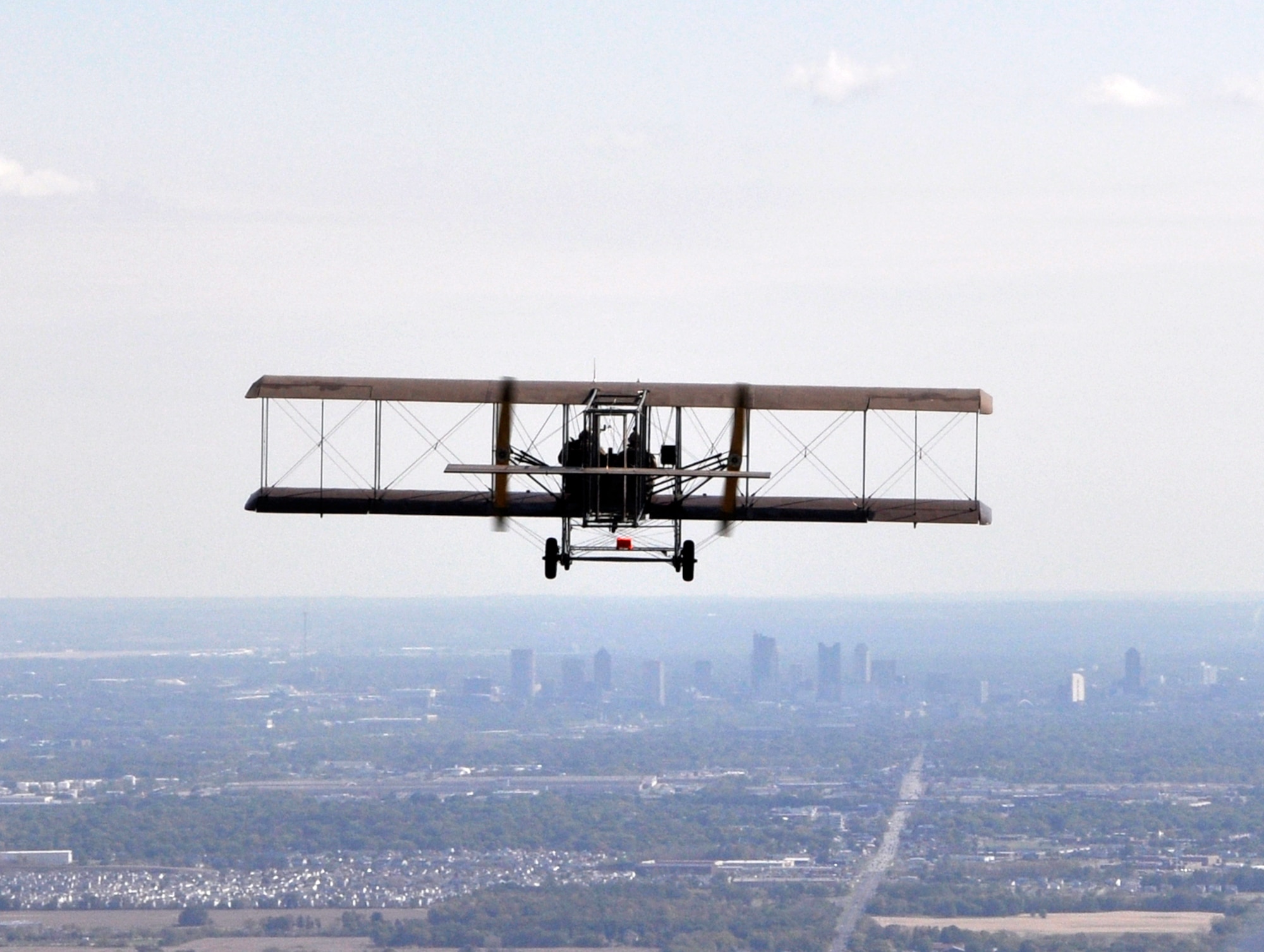 A lookalike Wright “B” Flyer approaches Columbus, Ohio during a Oct. 2, 2010 reenactment of the world’s first cargo flight. The original flight took place Nov. 7, 1910, and was made by Wright Company pilot Phil Parmelee from Huffman Prairie Flying Field (now part of Wright-Patterson Air Force Base) to Columbus. While the original cargo was 200 pounds of silk cloth, the Air Force Research Laboratory provided an advanced ceramic matrix composite fabric and conceptual models of micro-aerial vehicles to serve a cargo for the reenactment. (Courtesy photo/Timothy R. Gaffney)
