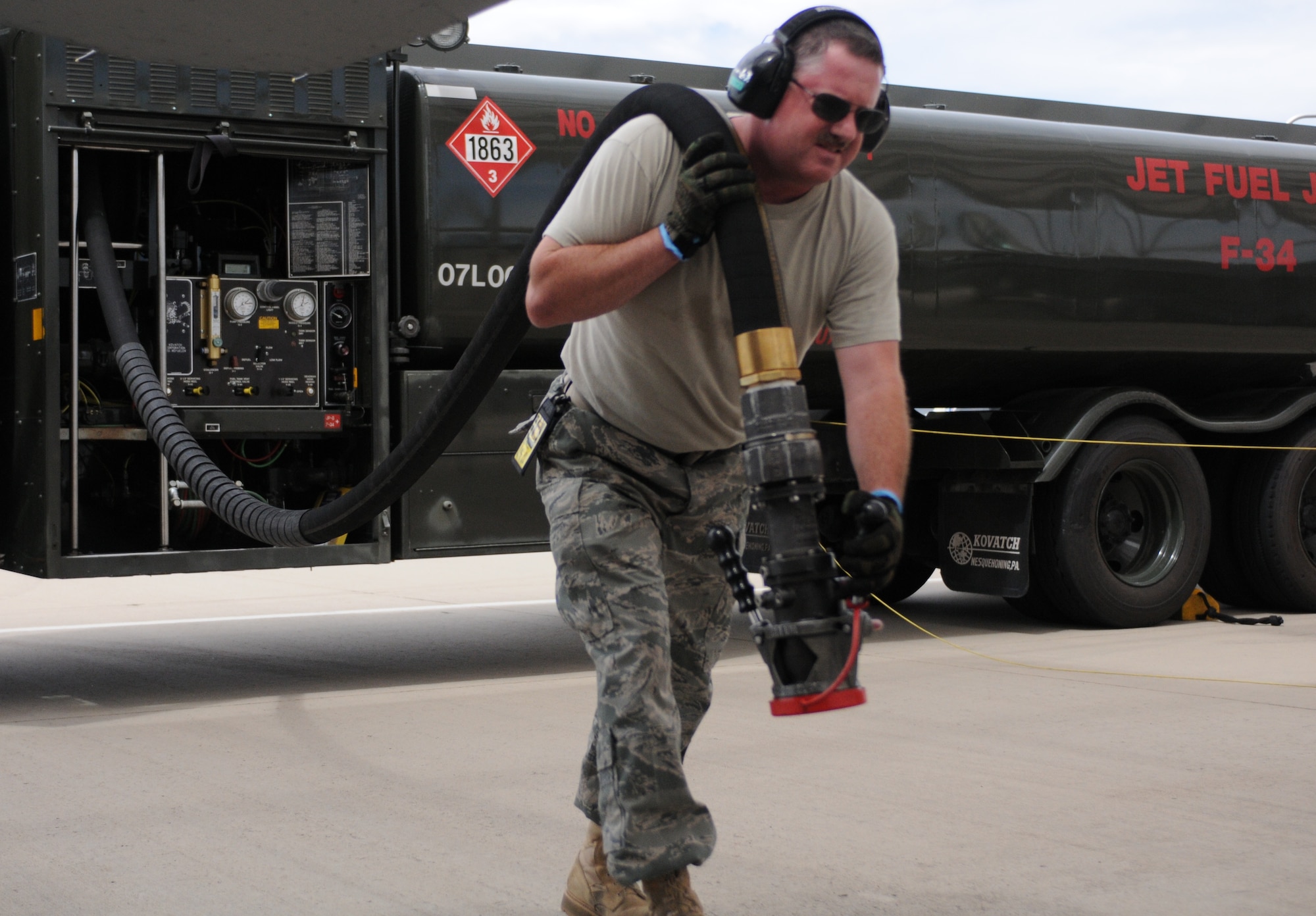 Staff Sgt. Buzz Decker drags a fuel hose from a 6,000-gallon tanker to an F-16 on the 162nd Fighter Wing flightline at Tucson International Airport; a process that is repeated nearly 1,200 times each month. (Air Force photo by Staff Sgt. Jordan Jones)