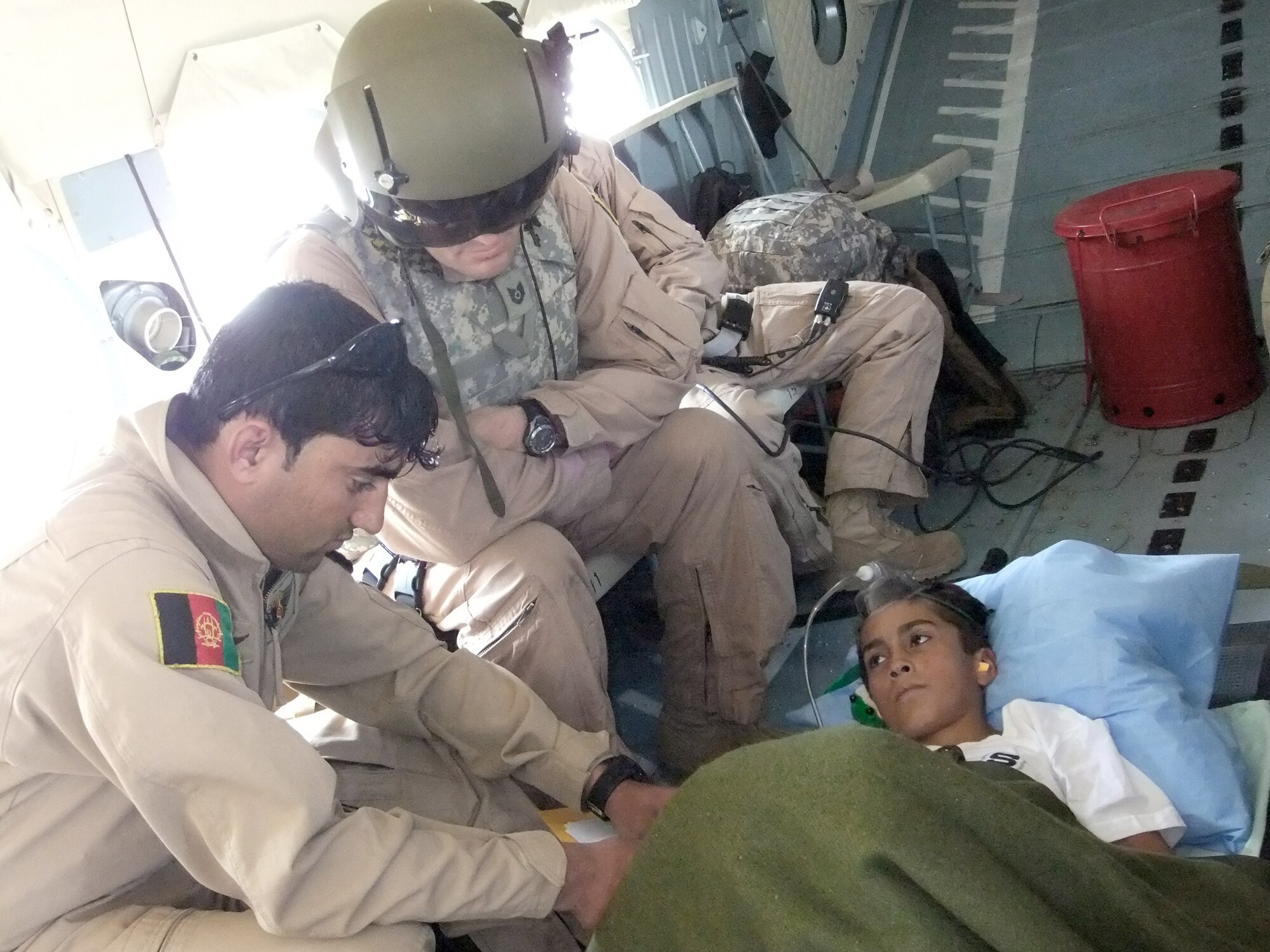 Afghan Airmen and NATO Air Training Command-Afghanistan advisers work as one to transfer a patient from Bagram Airfield, Afghanistan, during a reverse aeromedical evacuation mission Sept. 27, 2010, to Forward Operating Base Bostic in Konar Province. (U.S. Air Force photo)
