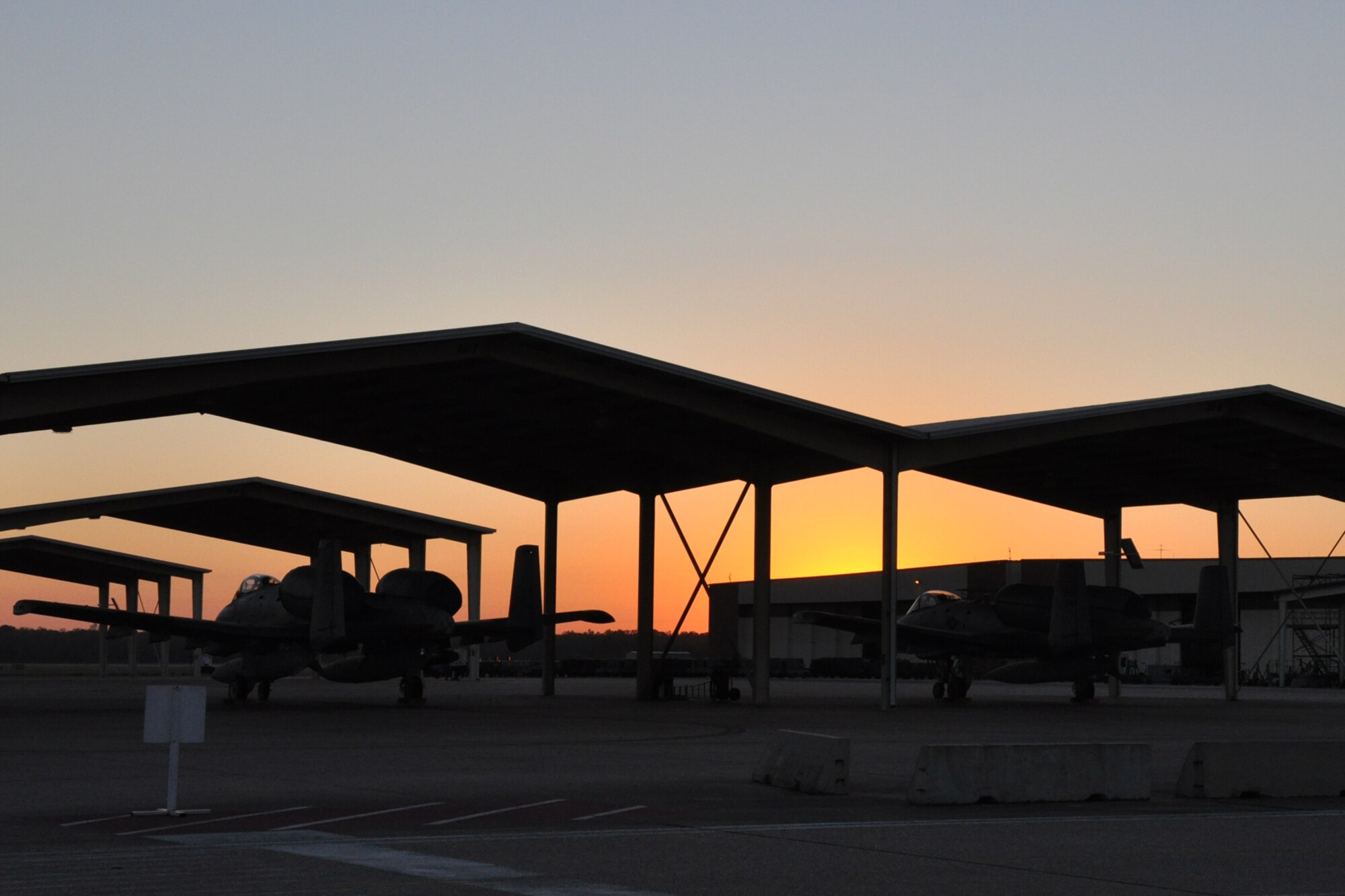 The sun slowly peaks over buildings on the southern ramp on Barksdale Air Force Base, La., as members of the 917th Wing start their Unit Training Assembly weekend Oct. 1, 2010. The 917th Wing is a composite wing which operates both the A-10A Thunderbolt II and the B-52H Stratofortress. Located at Barksdale AFB, the Wing employs approximately 1,700 Air Force Reserve personnel. (U.S. Air Force photo/Tech. Sgt. Jeff Walston)