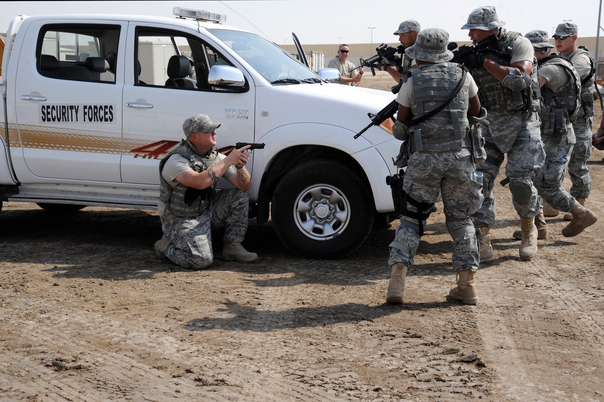 (Left) Staff Sgt. Clifford Dixon, 380th Expeditionary Security Forces Squadron combat readiness course cadre, is surrounded by students during vehicle assault training Sept. 28, 2010, at an undisclosed location in Southwest Asia. Vehicle assault training is part of a combat readiness course for security forces Airmen that was designed to help retain skill proficiencies, build team work and prepare personnel to react to a variety of situations. (U.S. Air Force photo/Tech. Sgt. April Wickes)