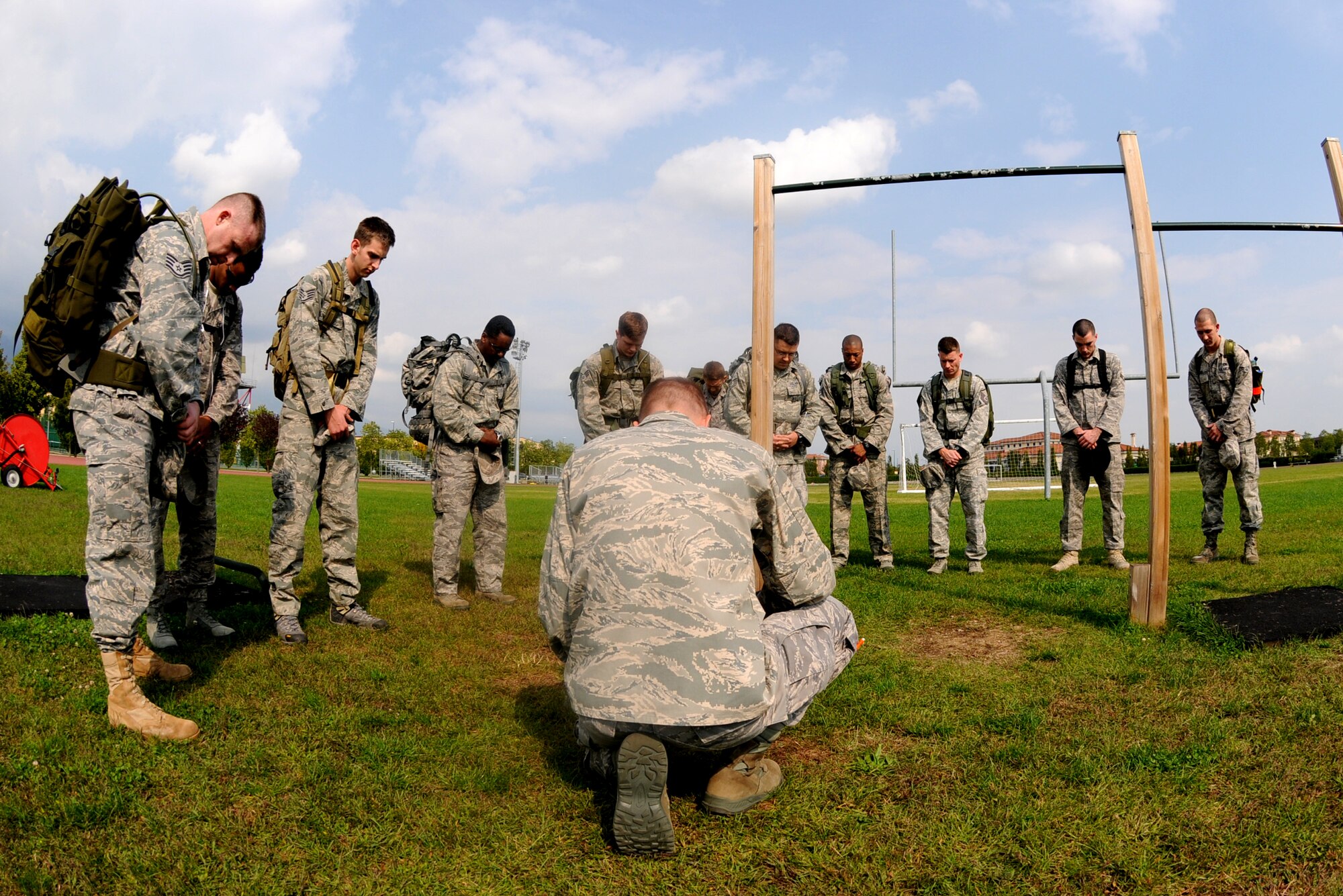 Airmen pray at the Dragon Fitness Center track before the 10K remembrance ruck march Sept. 30 as part of the POW/MIA Week commemoration activities. (U.S. Air Force photo/Staff Sgt. Julius Delos Reyes)