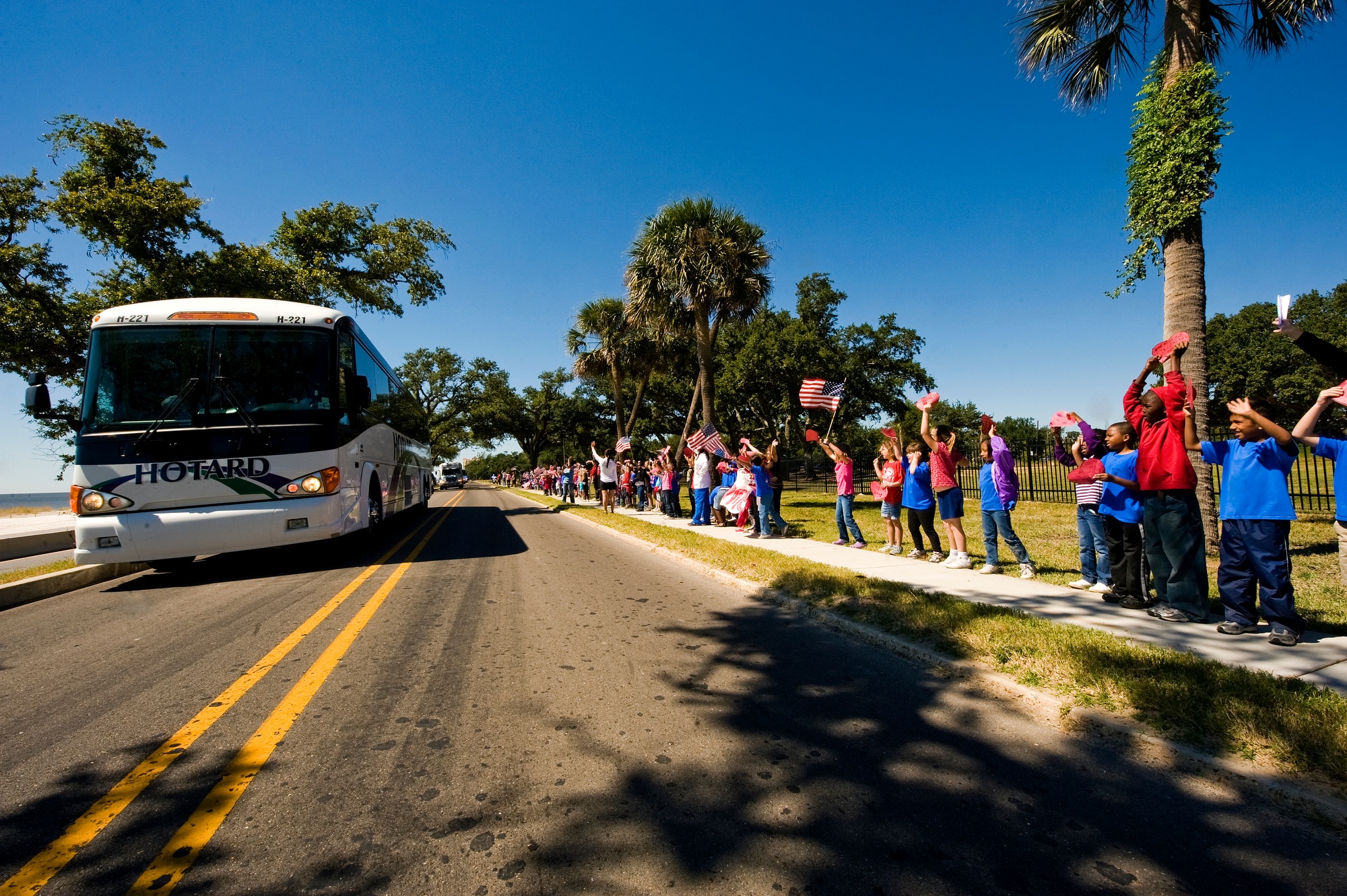Local school children line the street waiving American flags to welcome home 110 displaced residents of the Armed Forces Retirement Home in Gulfport, Miss., Oct. 4, 2010, from Washington D.C. Nearly 150 veterans returned home to south Mississippi after being forced to evacuate five years ago due to Hurricane Katrina. (U.S. Air Force photo/Tech. Sgt. Bennie J. Davis III)