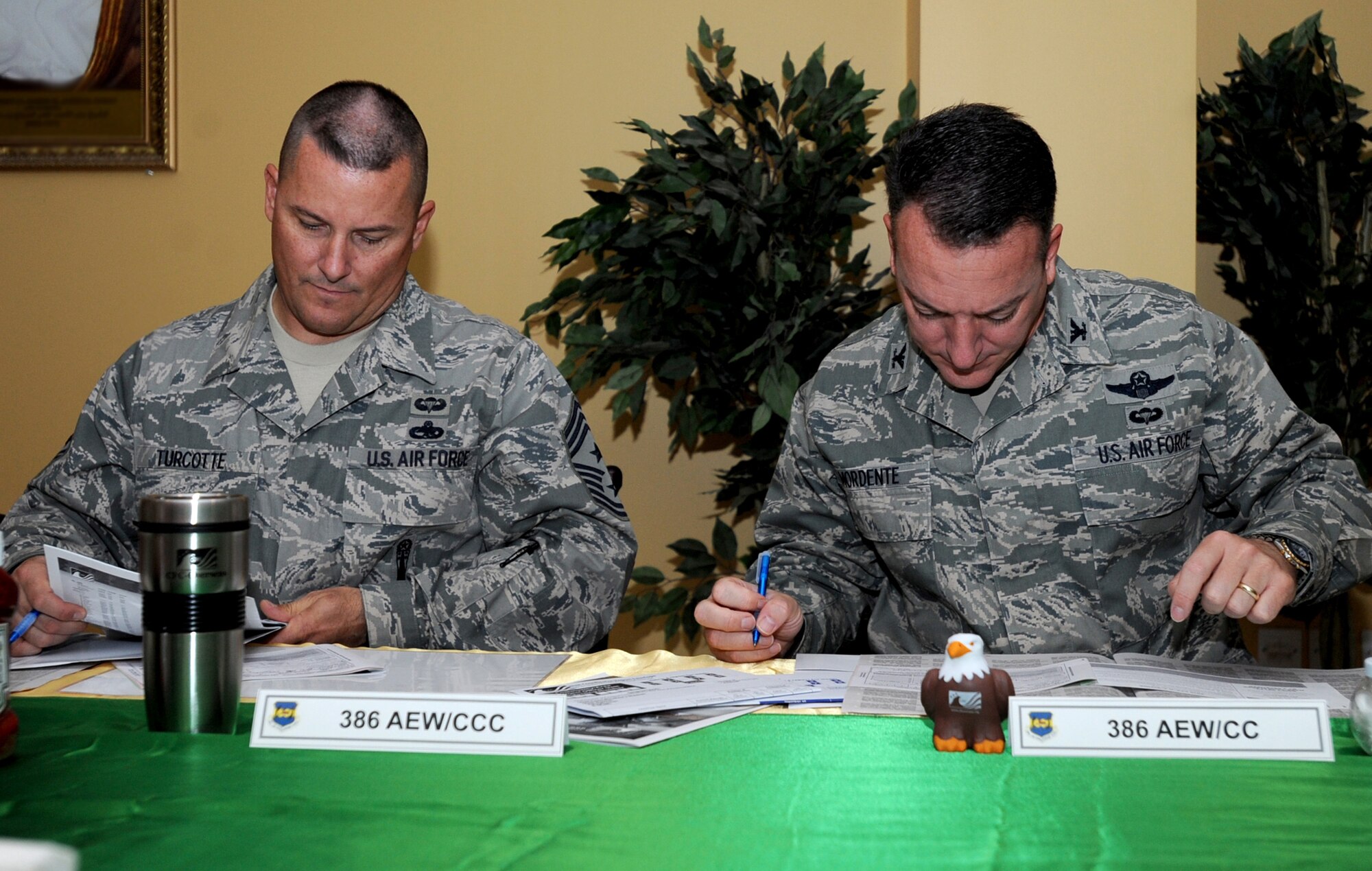 SOUTHWEST ASIA - Chief Master Sgt. Richard J. Turcotte, 386th Air Expeditionary Wing command chief, and Col. Patrick Mordente, 386th AEW commander, sign pledge cards here Oct. 4, 2010, during a kick-off breakfast for this year's Combined Federal Campaign-Overseas. The fund-raising effort, which will run through Dec. 3, is the only authorized solicitation of Federal employees on behalf of approved charitable organizations. (U.S. Air Force photo by Senior Airman Laura Turner)