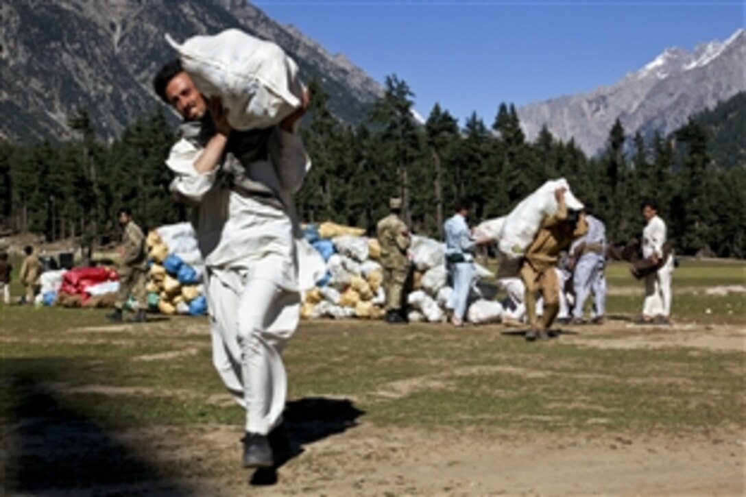 A Pakistani man loads produce onto a U.S. Army CH-47 Chinook helicopter in Kalam, Pakistan, Oct. 3, 2010. Pakistanis have been recovering from record floods for several weeks, and have been unable to get their goods to market. The U.S. military has provided humanitarian and disaster relief for the victims.