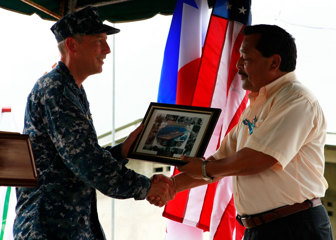 Left to right, U.S. Navy Capt. Thomas M. Negus, commodore for Operation Continuing Promise 2010, presents a plaque to Dr. Jose Stonestreet, regional director for Ministry of Health, Comarca, Ngabe Bugle, at a closing ceremony of humanitarian assistance operations in Chiriqui Grande, Panama, Oct. 6, 2010. Service members and civilians are deployed in support of CP10 providing medical, dental, veterinary, engineering assistance and subject-matter exchanges to Caribbean, Central and South American nations.