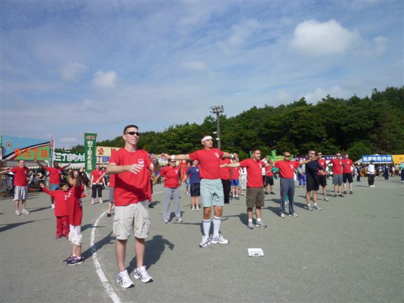 YOKOTA AIR BASE, Japan -- Members from the 374th Maintenance Group participate in the 51st Mizuho Town Sports Day, Oct. 3, by warming up with a Japanese radio exercise. The town sports day gave American service members the chance to relax and have fun interacting with local Japanese people. (U.S. Air Force photo/Naoko Kurokui)