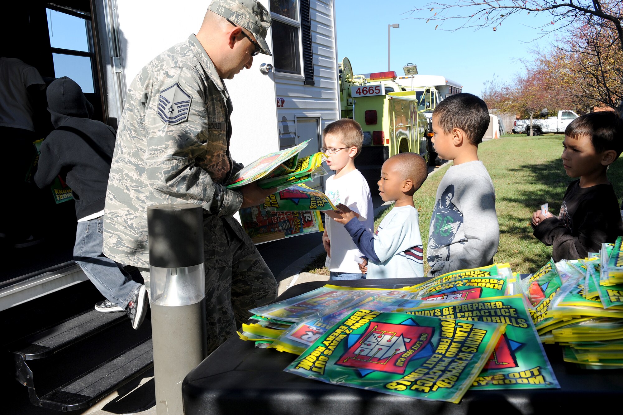 Master Sgt. Sean McCauley, 375th Civil Engineer Squadron firefighter, hands out fire safety activity packs to children at the Youth Center Oct. 5. In honor of Fire Safety Awareness Week, the Scott Air Force Base Fire Department will provide fire safety awareness education and training throughout the week of Oct. 3-9. (U.S. Air Force photo/Staff Sgt. Brian J. Valencia)