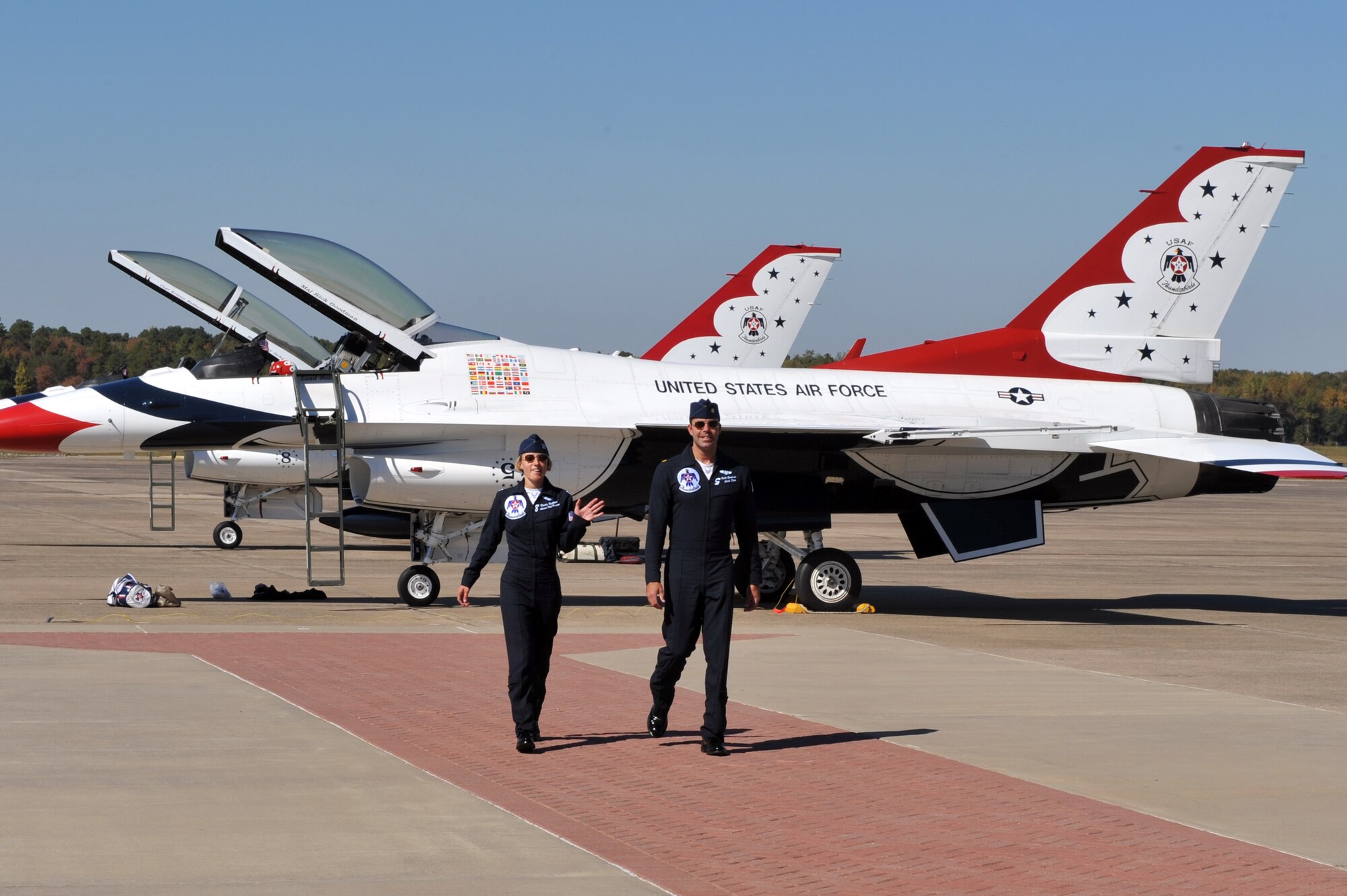 Maj. Rick Goodman, No. 5, and Capt. Kristin Hubbard, No. 8, both members of the Air Force Thunderbirds F-16 demonstration team, walk towards base operations after landing on the base flightline Oct. 6. The Air Force Thunderbirds F-16 demonstration team is headlining the base’s air show Oct. 9-10.  (U.S. Air Force photo by Staff Sgt. Chris Willis)