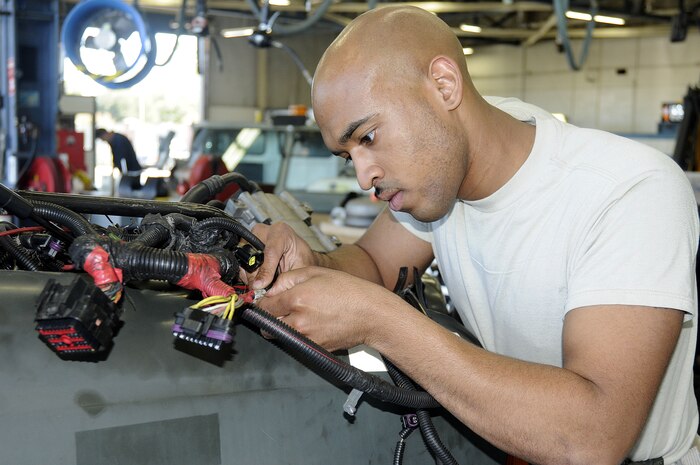Airman 1st Class Valentino Coward, from the 628th Logistics Readiness Squadron vehicle maintenance section, searches for a part number on a engine wiring harness for a parts replacement on a government vehicle.  The 628 LRS vehicle maintenance section maintains and repairs government-owned equipment and vehicles for Joint Base Charleston. (U.S. Navy photo/Mass Communications Specialist 1st Class Jennifer Hudson.)