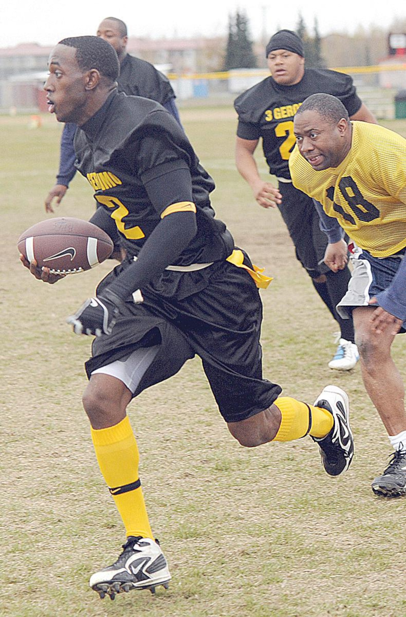 Patrick Spence, quarterback for the 3rd Battalion, 509th Infantry Regiment (Airborne) flag football team, scrambles for extra yardage against the 3rd EMS defense. (U.S. Air Force photo/John Pennell)