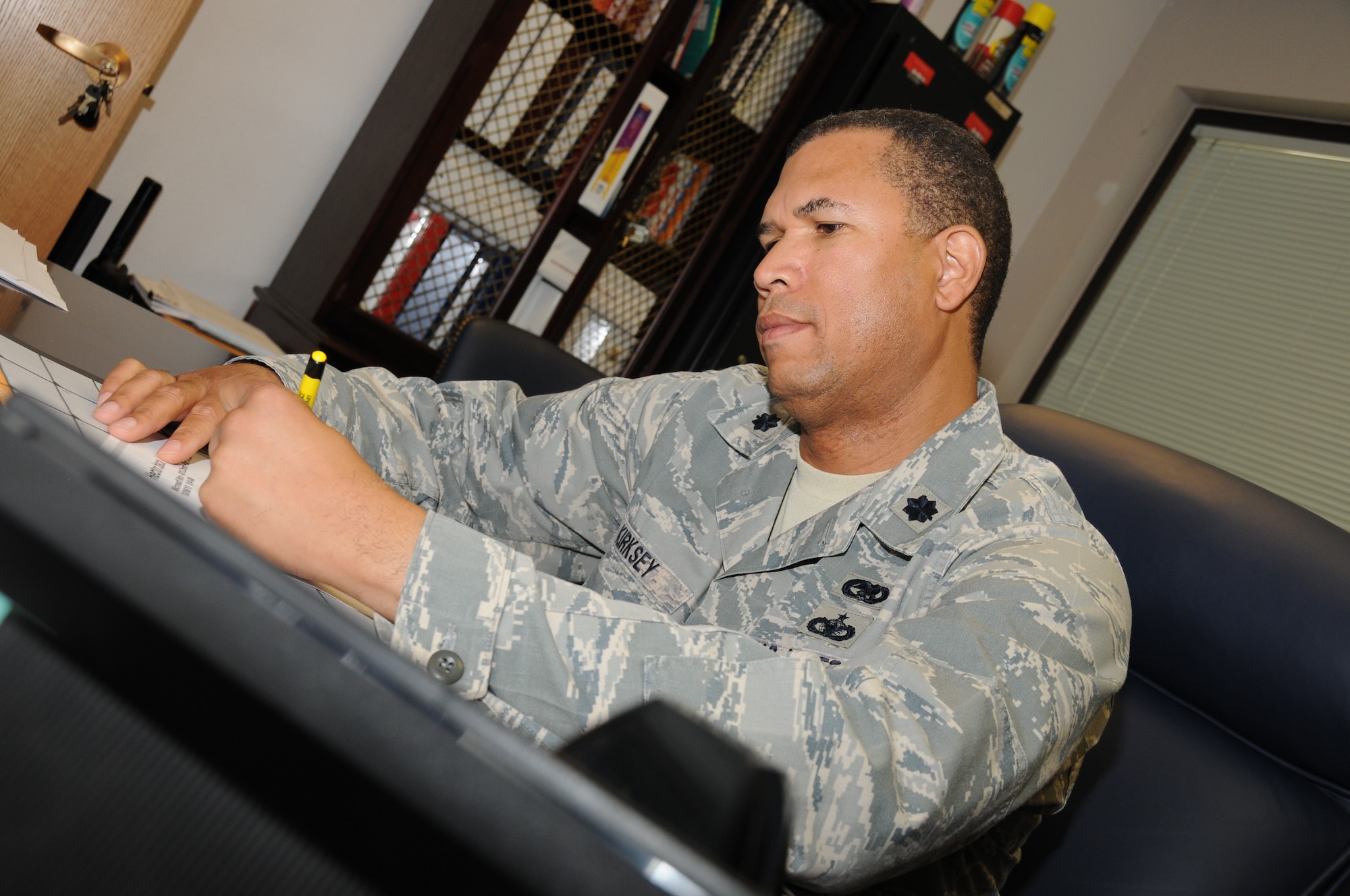 Lt. Col. Allen Kirksey, 161st Logistics and Readiness Squadron commander, engages in logistics paperwork similar to his tasks during a recent deployment where he orchestrated the return of fallen warriors. (U.S. Air Force Photo by Senior Airman Nicole Enos) 
