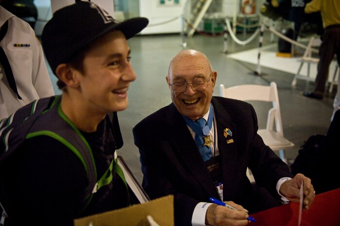 Medal of Honor recipient Hershel W. Williams jokes after autographing a young patron?s book during an autograph session, Sept. 30, 2010, at Patriots Point Naval and Maritime Museum in Mount Pleasant, S.C. The Medal of Honor Convention is an annual event hosted by a different city each year to honor Medal of Honor recipients as well as all service members who protect American freedoms. The 2010 Medal of Honor Convention was hosted by the South Carolina State Guard Foundation and The Citadel, the military college of South Carolina. Fifty-five of the 87 living recipients attended this year's convention. (U.S. Air Force photo/Staff Sgt. Manuel J. Martinez)