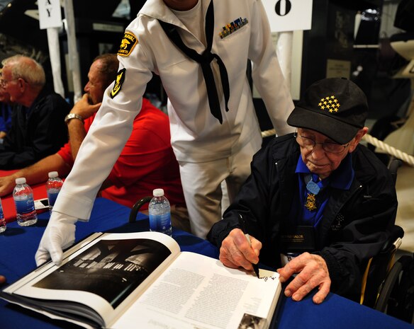 Nicholas Oresko signs autographs at a book signing at Patriots Point Naval and Maritime Museum in Mount Pleasant, S.C., during the week of the Medal of Honor Convention held in Charleston, S.C., Sept. 30, 2010. Nicholas Oresko, born Jan. 18, 1917, is a former United States Army Soldier and a recipient of the Medal of Honor for his actions in the Battle of the Bulge during World War II. The Medal of Honor Convention is an annual event hosted by a different city each year to honor Medal of Honor recipients as well as all service members who protect American freedoms. The 2010 Medal of Honor Convention was hosted by the South Carolina State Guard Foundation and The Citadel, the military college of South Carolina. Fifty-five of the 87 living recipients attended this year's convention. (U.S. Air Force photo/Airman 1st Class Samuel W. Goodman)